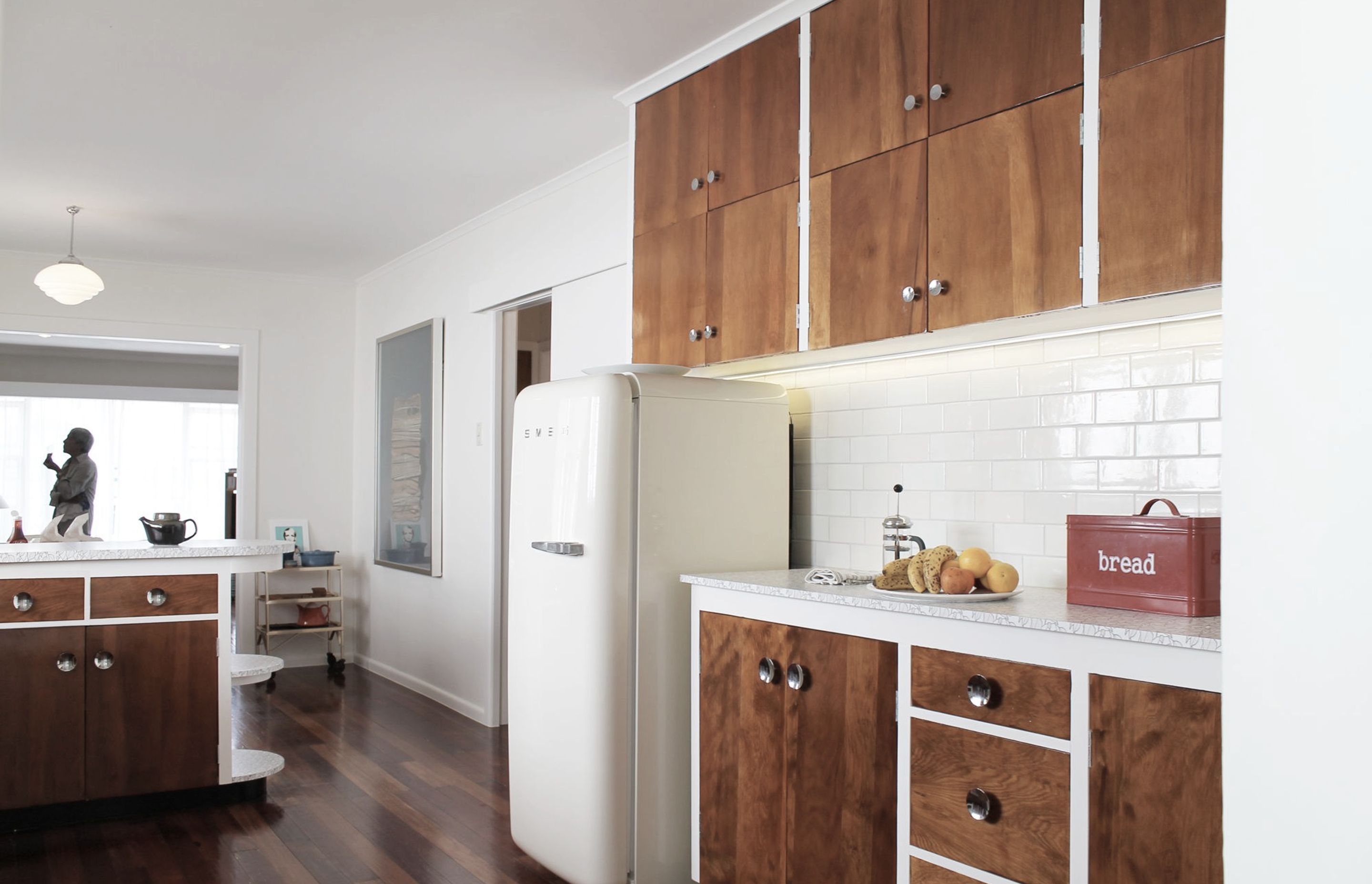 Years of old paintwork were stripped away to reveal a rich grain in the original woodwork. During the day natural light floods the space and highlights this rediscovered timber and the new Formica patterned benchtop. The soft tones of the walls and tiles 
