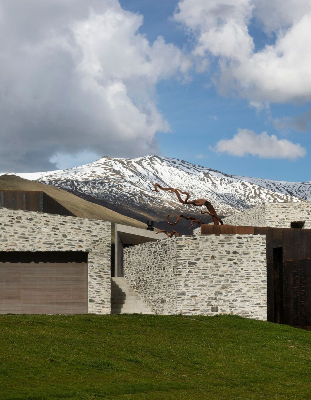 The entrance is a stone staircase with a direct view of the Alps.