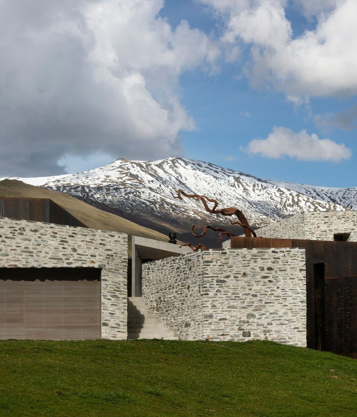 The entrance is a stone staircase with a direct view of the Alps.