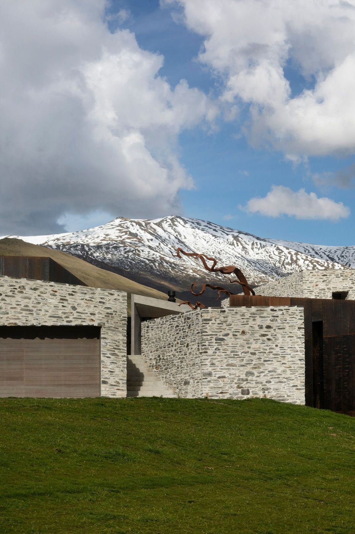 The entrance is a stone staircase with a direct view of the Alps.