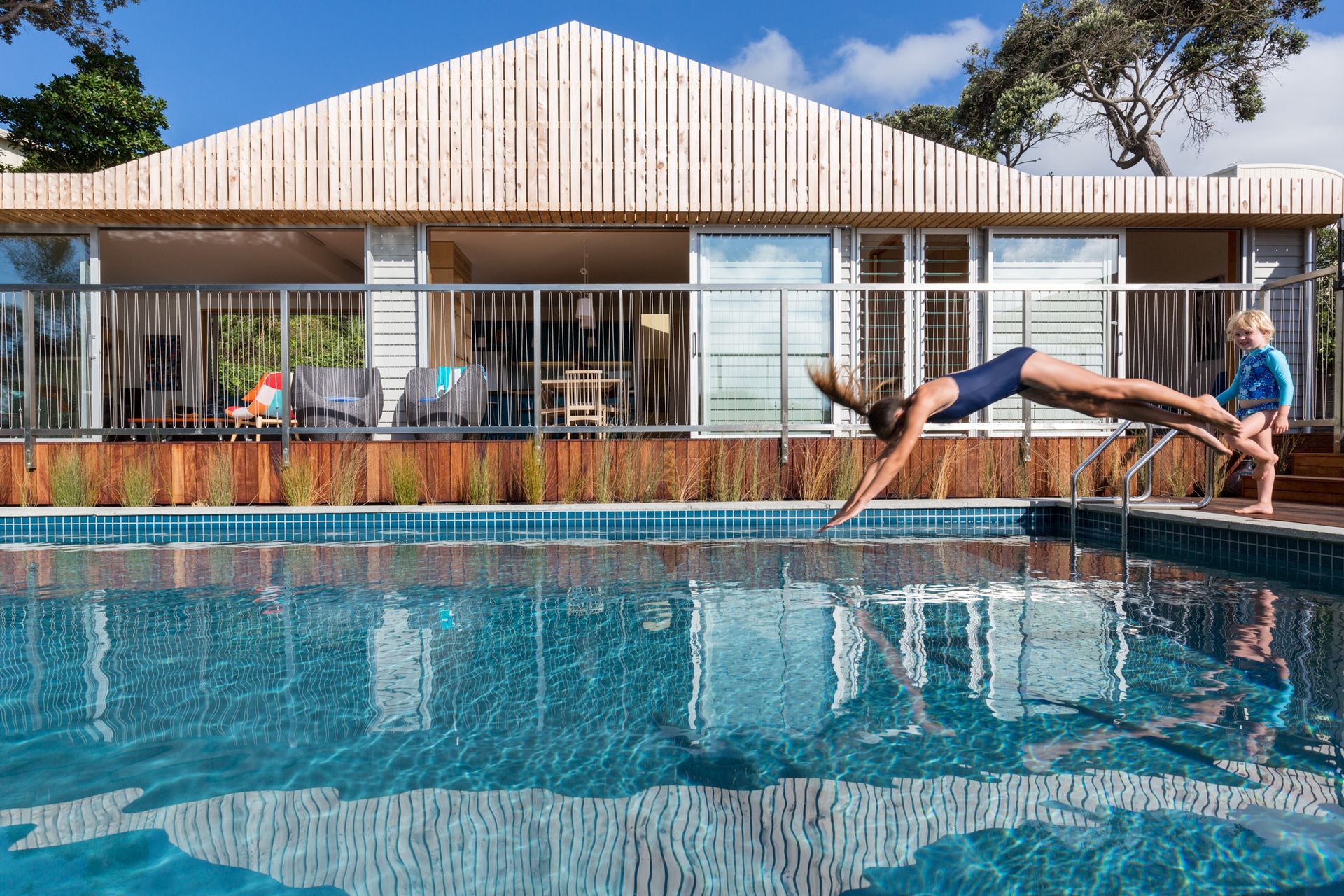 The swimming pool, added to the property in the 1950s has been fully refurbished. Bevelled weatherboards reference the original cottage while slatted macrocarpa elements add new definition and help mitigate excess solar gain.