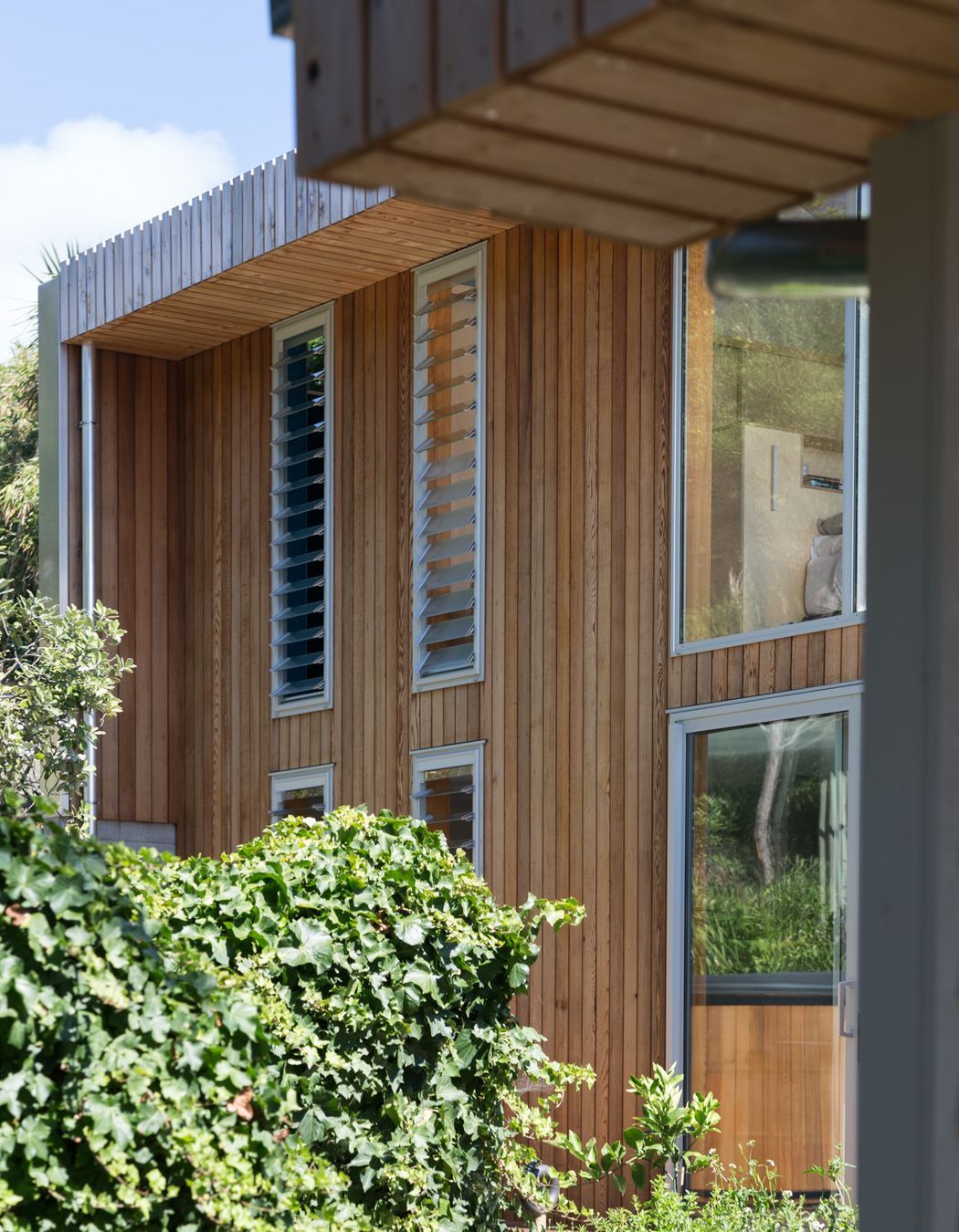 Vertical cedar cladding makes for a contemporary addition to the bevelled weatherboards of the original cottage.