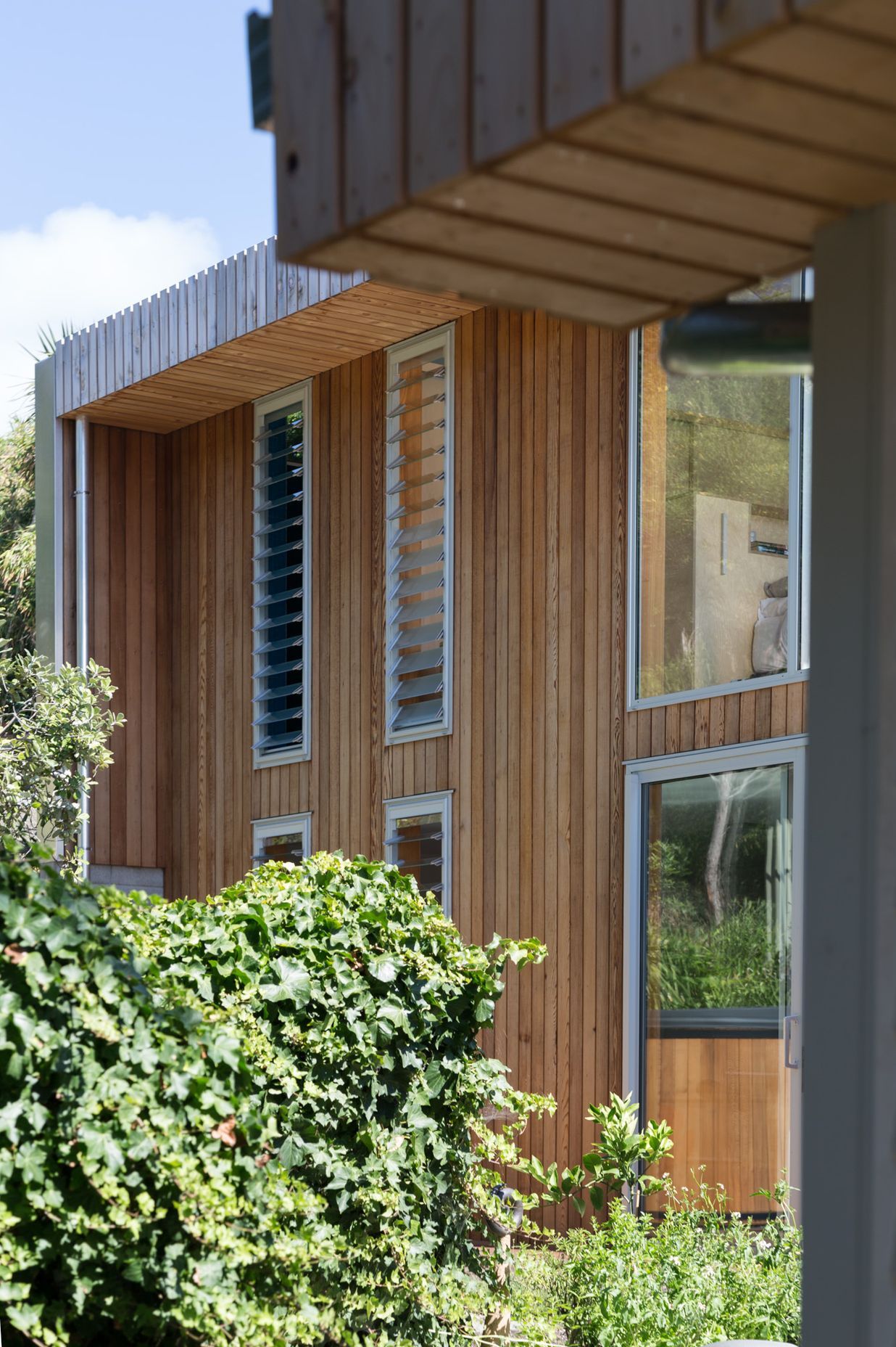 Vertical cedar cladding makes for a contemporary addition to the bevelled weatherboards of the original cottage.