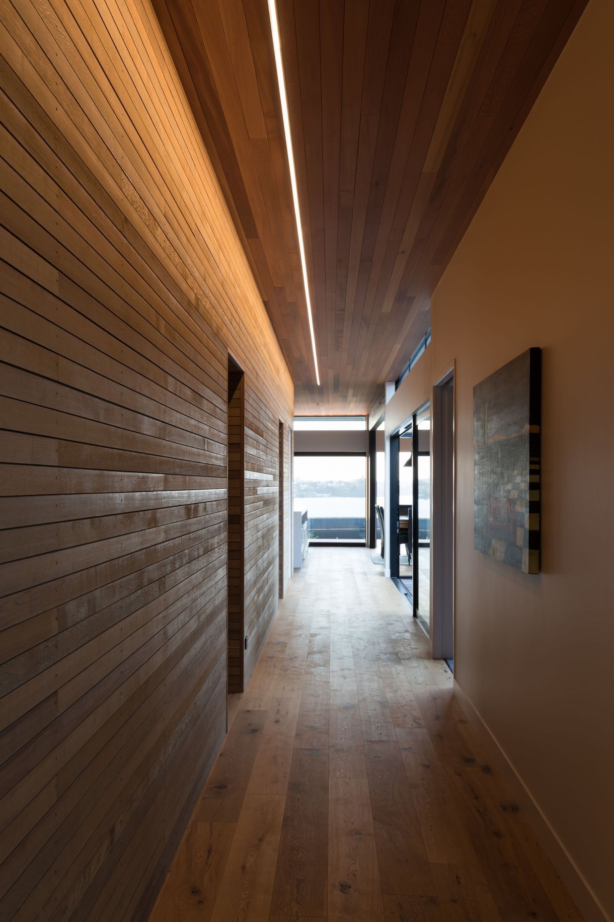 The gallery serves to draw visitors past the internal courtyard and lap pool, towards the waterfront, aided by the strip lighting in the ceiling. The bedrooms and bathrooms pass by, discrete and unnoticed.
