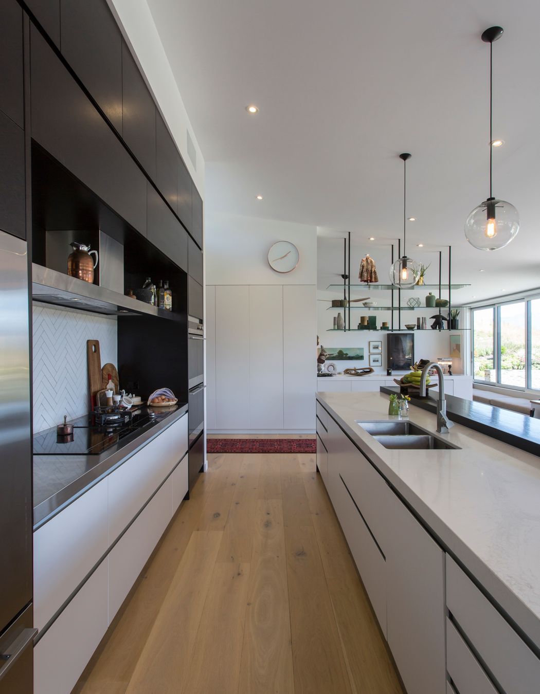 Handleless cabinetry and integrated appliances keep the working heart of the kitchen sleek and unobtrusive.