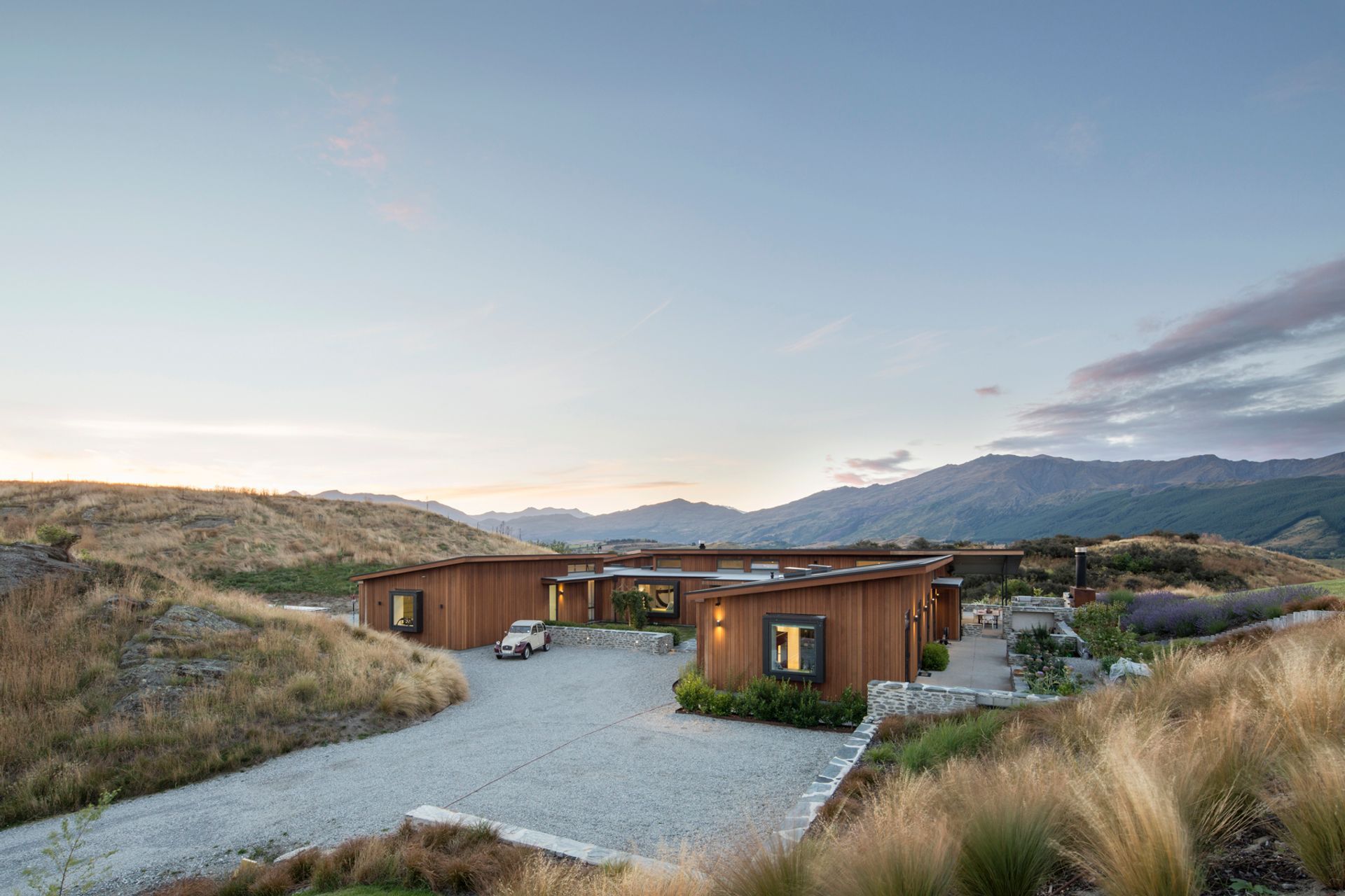 Nestled into an idyllic rural property—part of a new development near Arrowtown—this family home is only revealed as you approach it around a rocky outcrop.