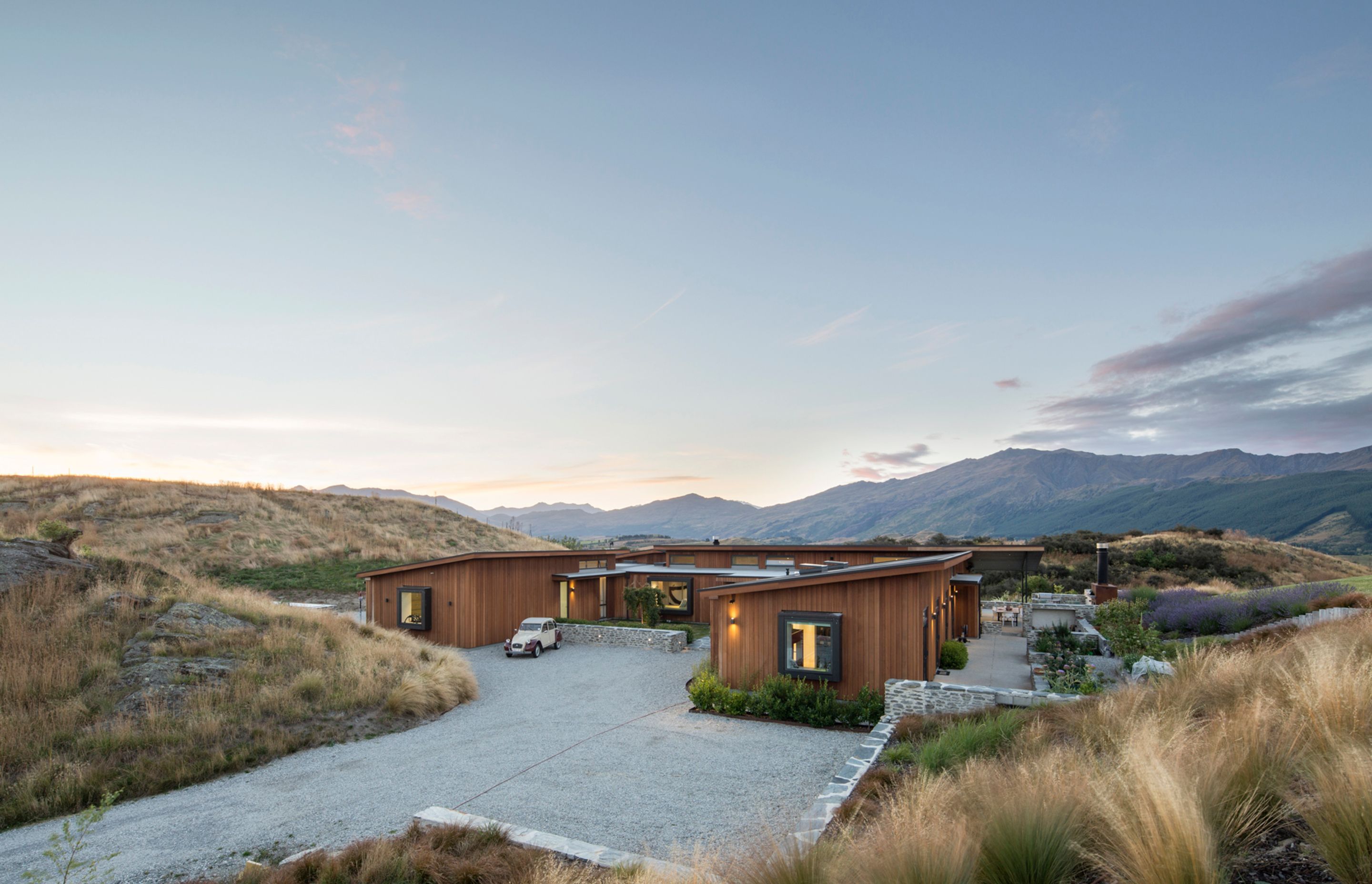 Nestled into an idyllic rural property—part of a new development near Arrowtown—this family home is only revealed as you approach it around a rocky outcrop.