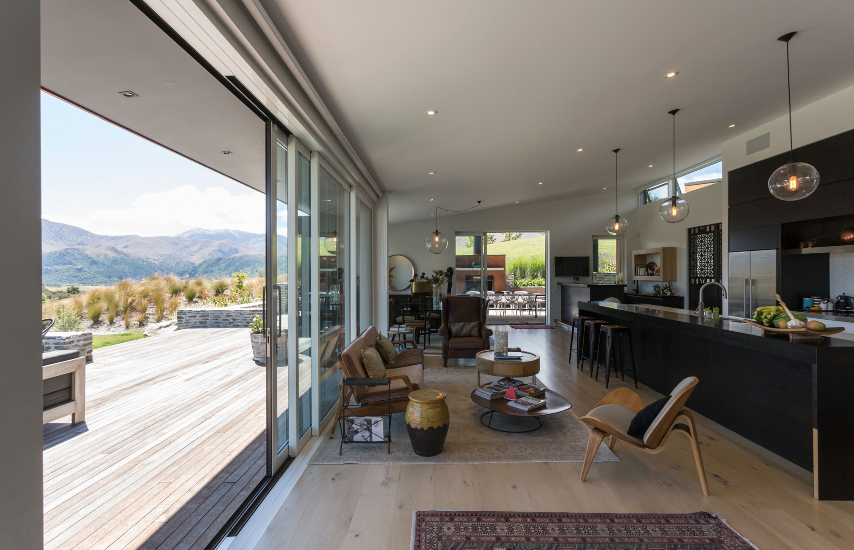 A casual living area leads onto a large deck, which is accessed via full-width stacking sliders.