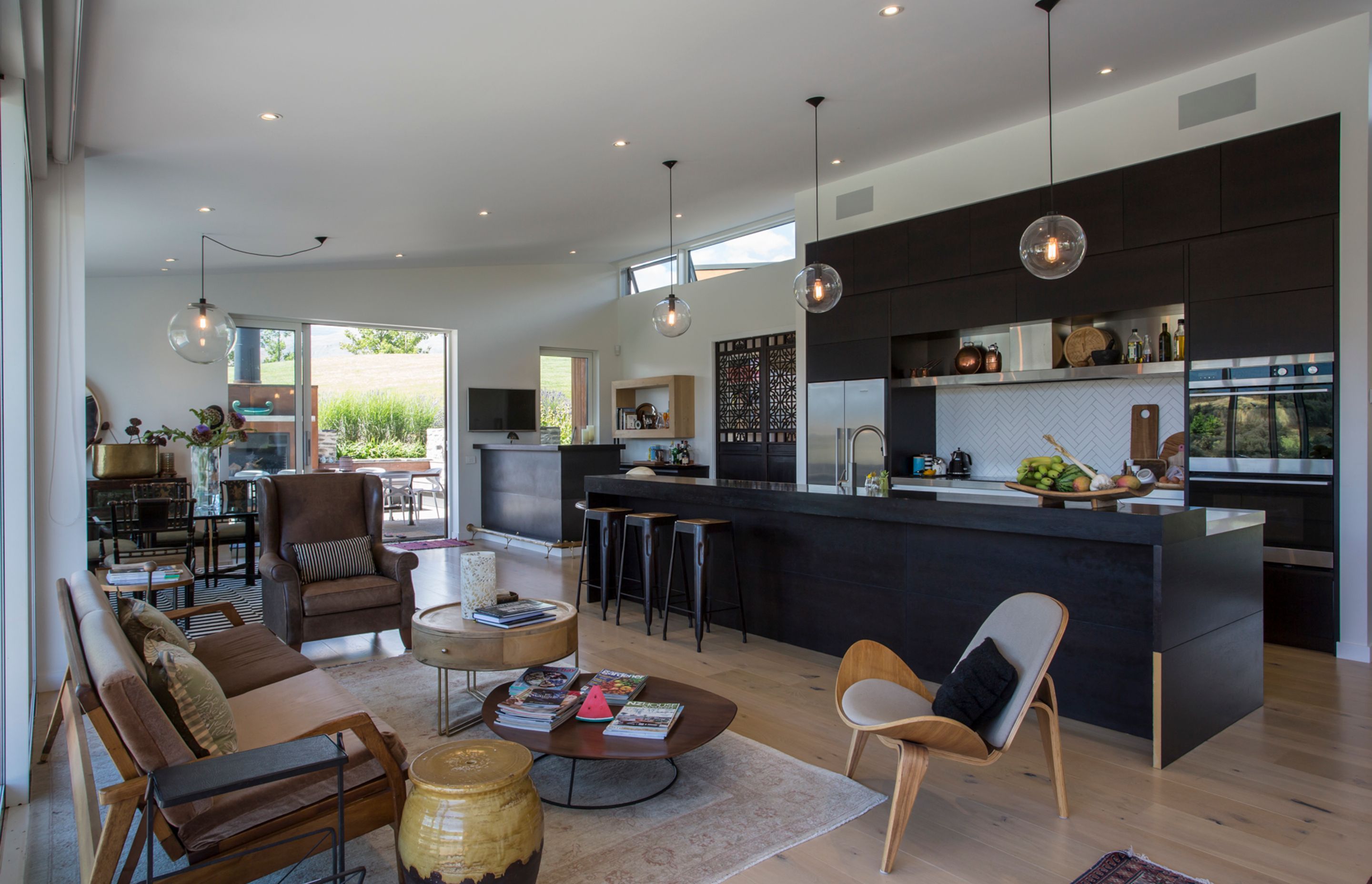Triple-aspect doors and windows—including clerestory windows above the bar area—ensure the interior of the home remains light-filled throughout the day. A modern take on the classic 'black and white' scheme keeps things clean and crisp.