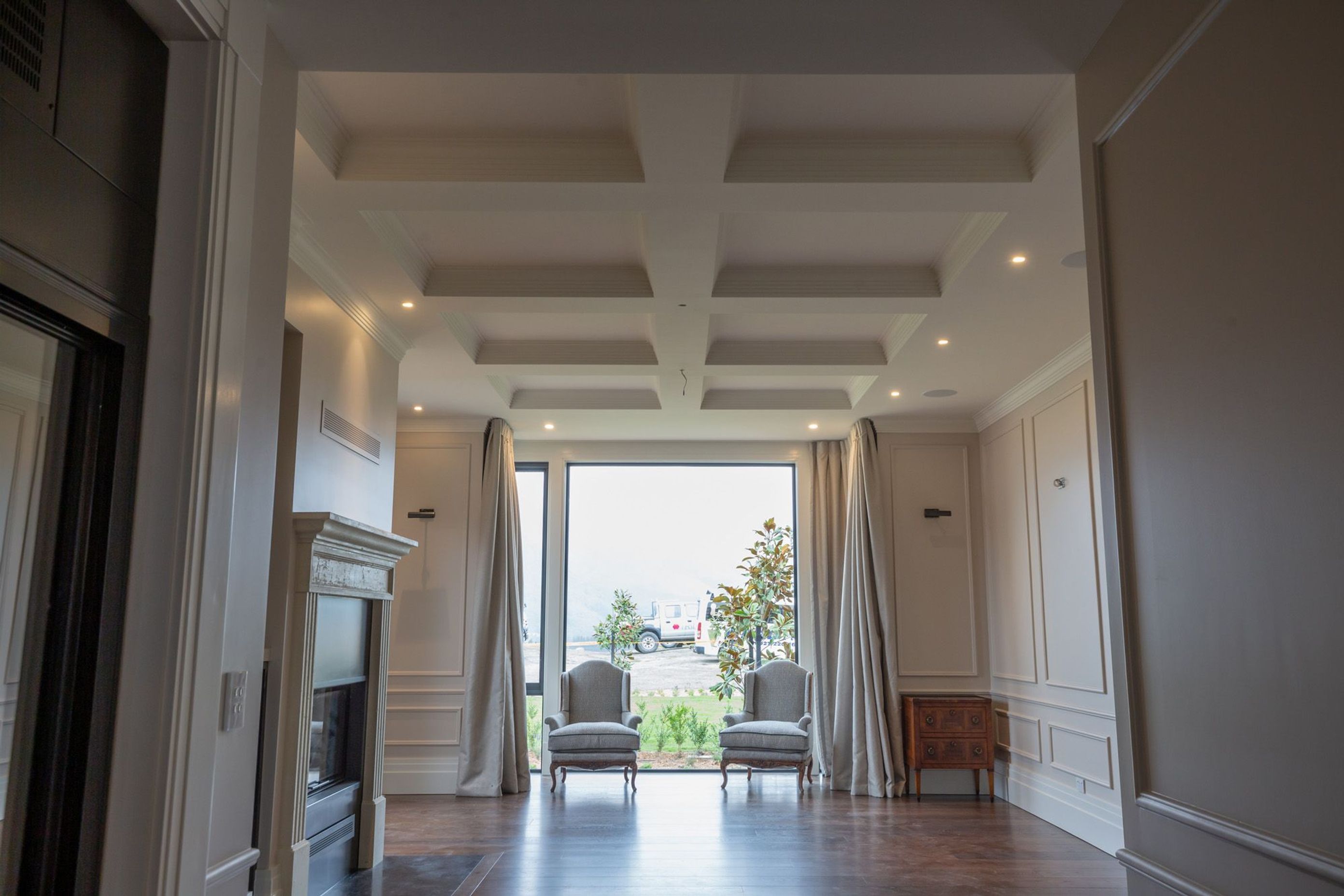 Custom-made fire surround, coffered ceiling with cornices, boxed wall panels and dado rails