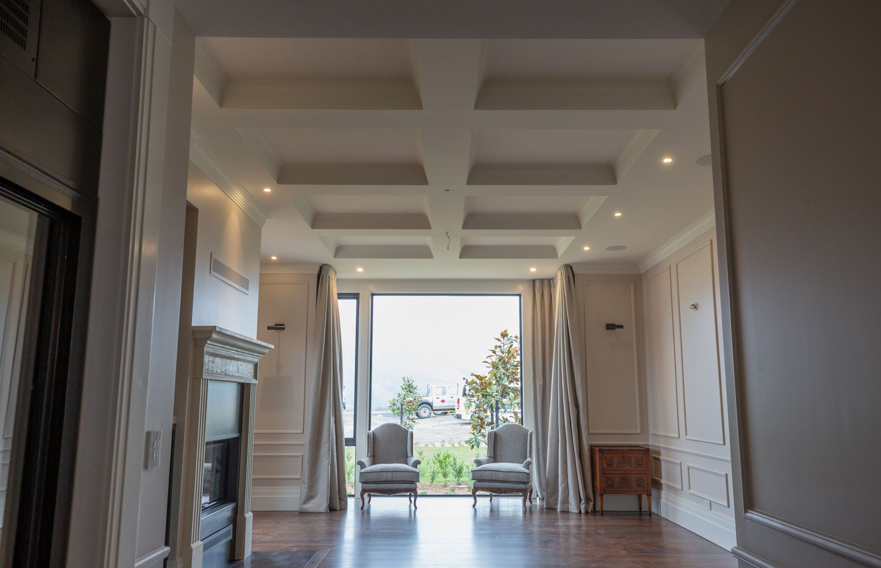 Custom-made fire surround, coffered ceiling with cornices, boxed wall panels and dado rails