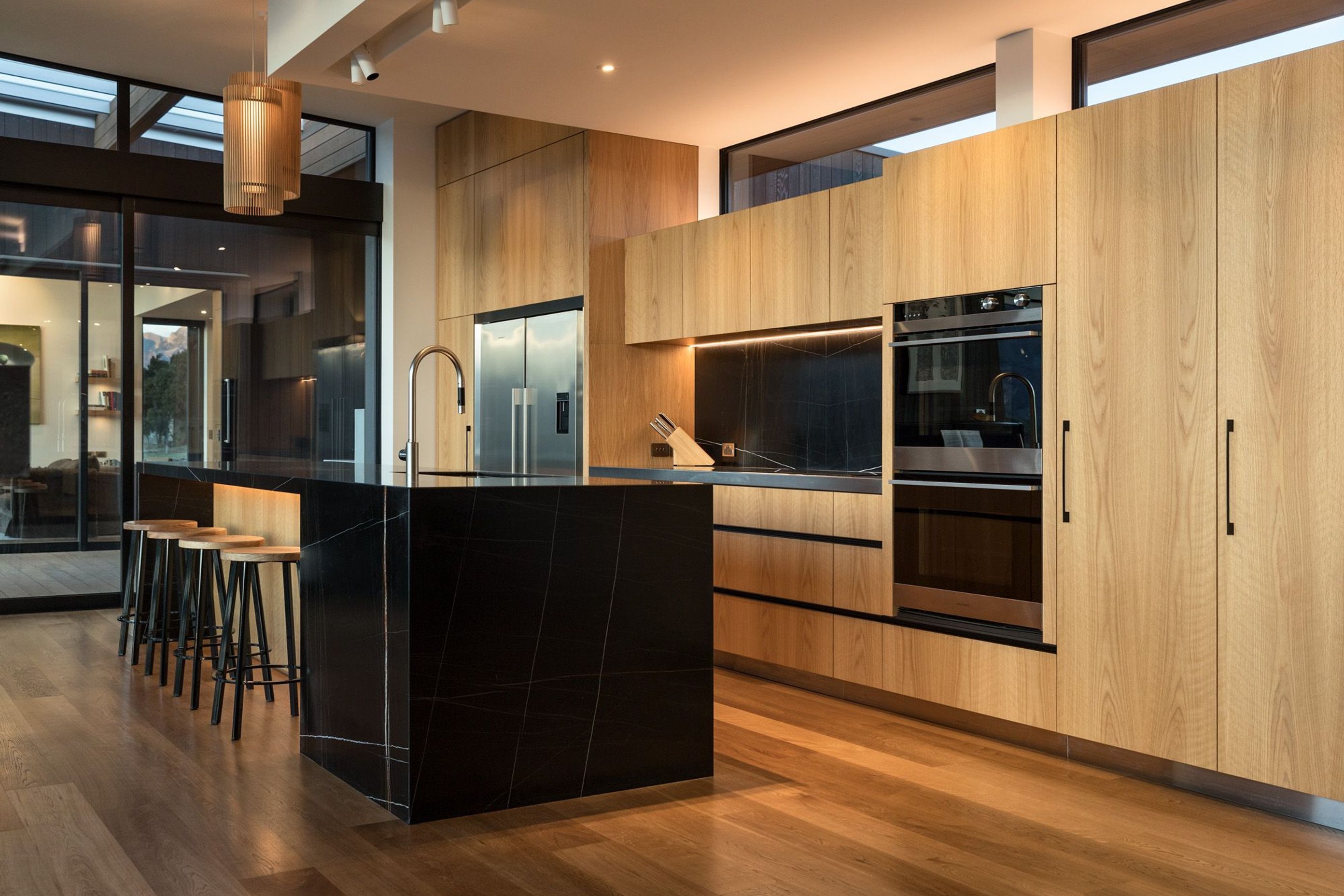 In the kitchen area, a black and gold marble honed slab countertop and splash back is a fitting showcase to the owner’s expertise as a geologist. 