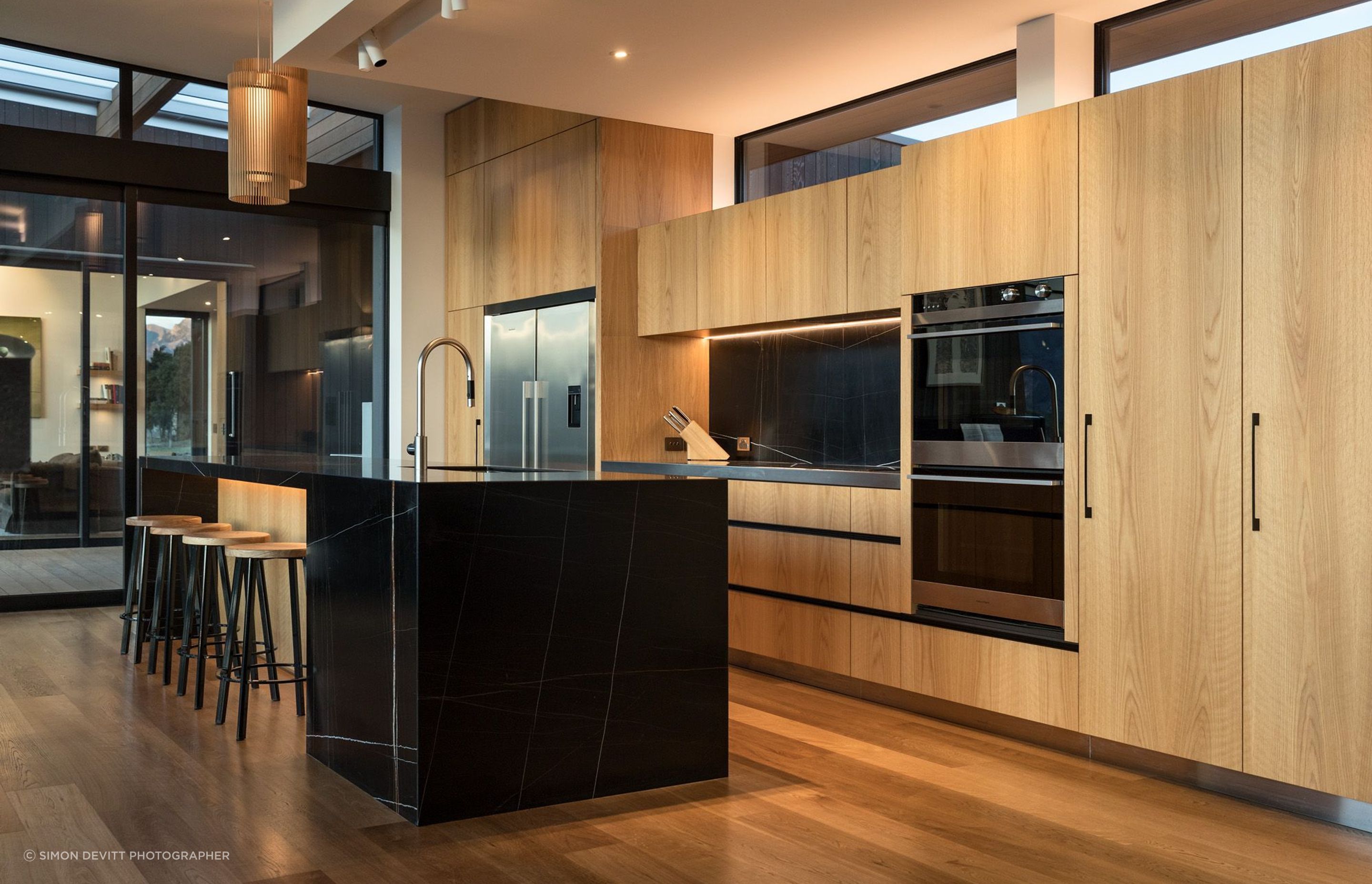 In the kitchen area, a black and gold marble honed slab countertop and splash back is a fitting showcase to the owner’s expertise as a geologist. 