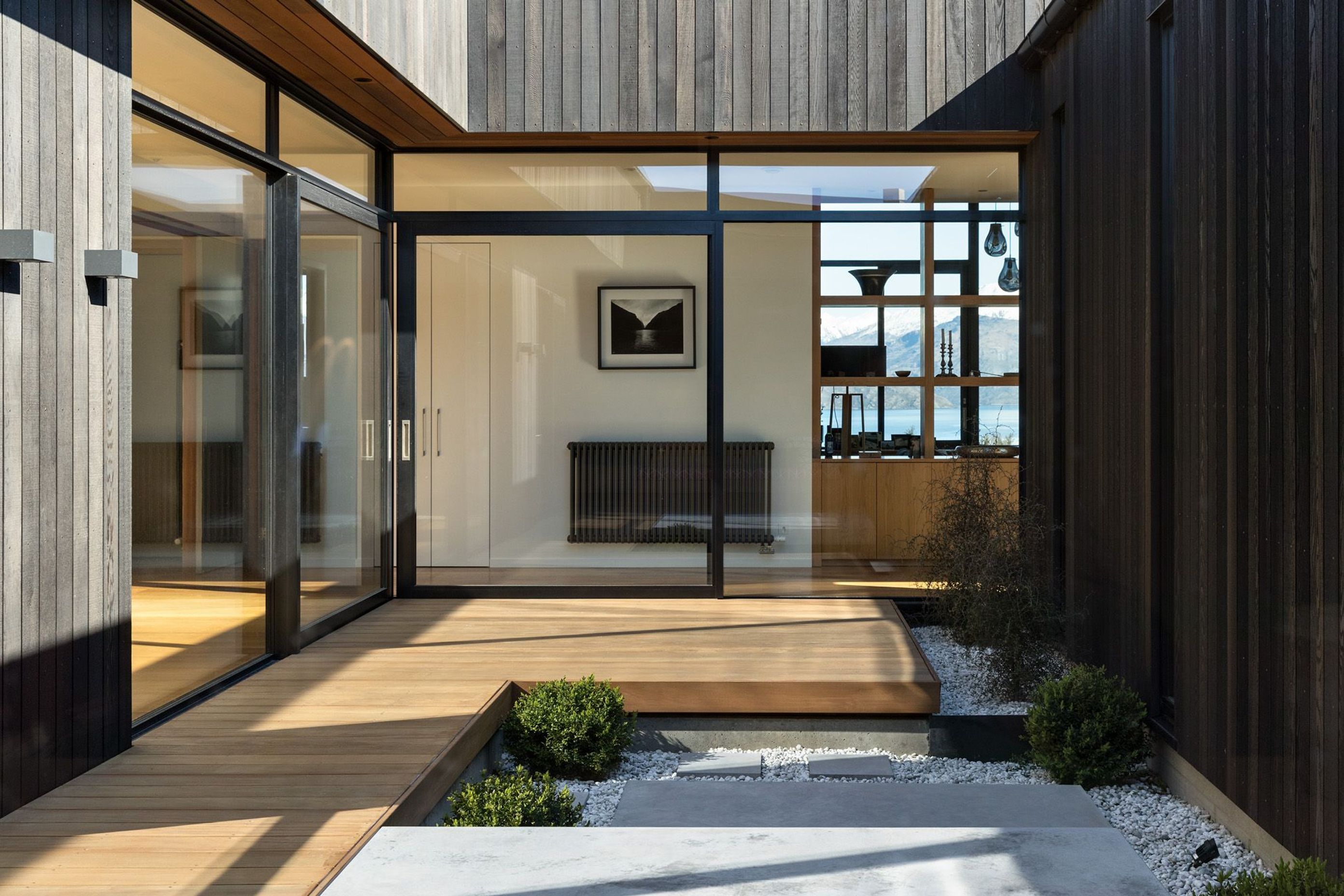 The central interior courtyard with two glass walls with corner opening doors is a light well that transforms otherwise south-facing rooms into areas bathed in sun and light. 