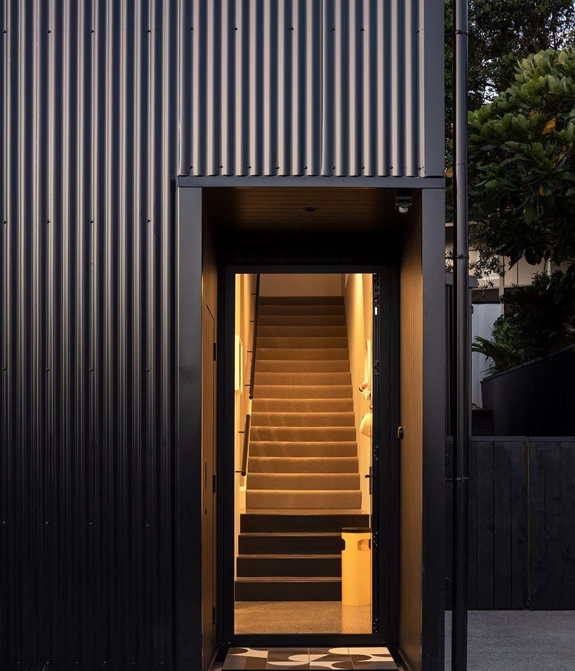The front entrance features a geometric tiled entry mat.