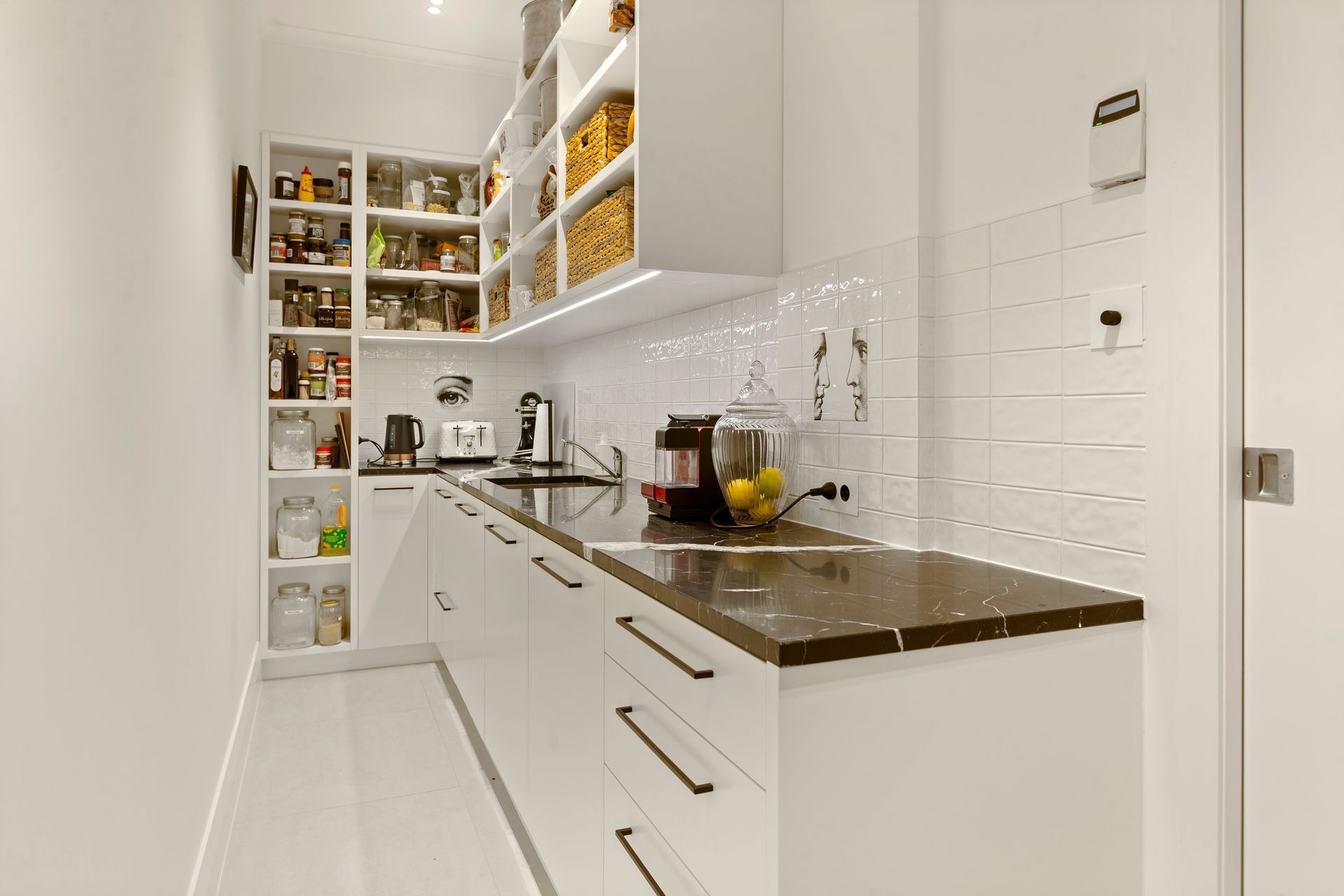 Concealed pantry hidden behind the kitchen allows for storage and prep away from the entertainment area, and equally is a beautiful space to work!
