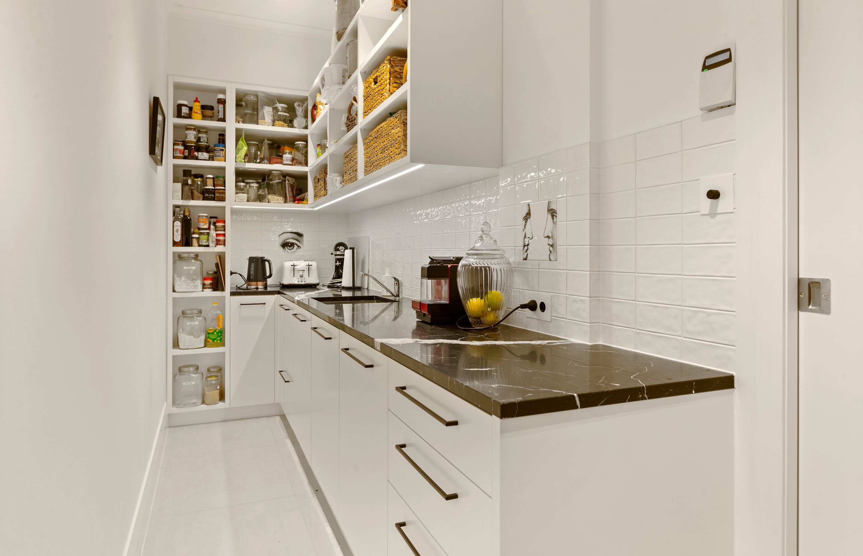 Concealed pantry hidden behind the kitchen allows for storage and prep away from the entertainment area, and equally is a beautiful space to work!