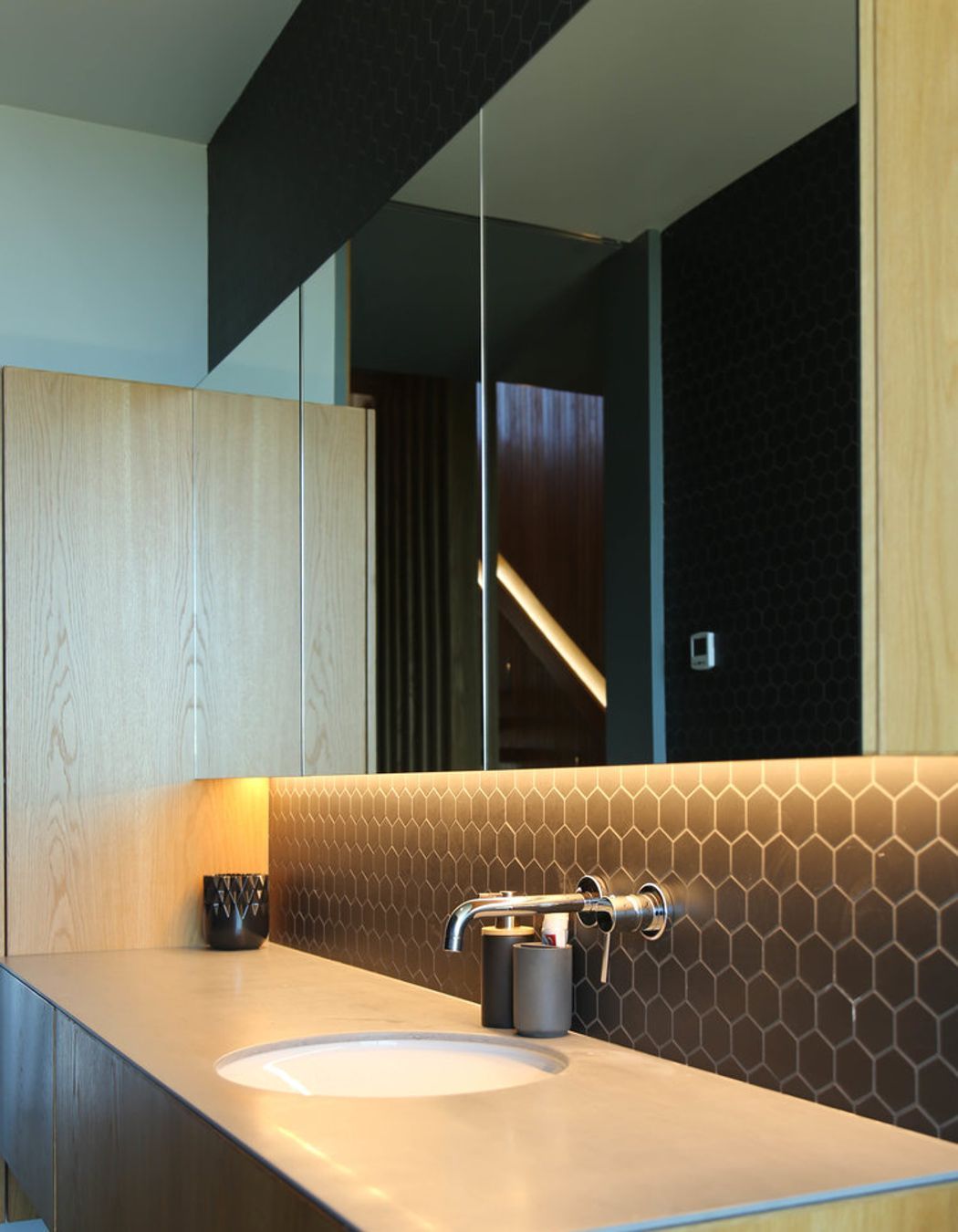 The bathroom continues a natural palette of materials theme.