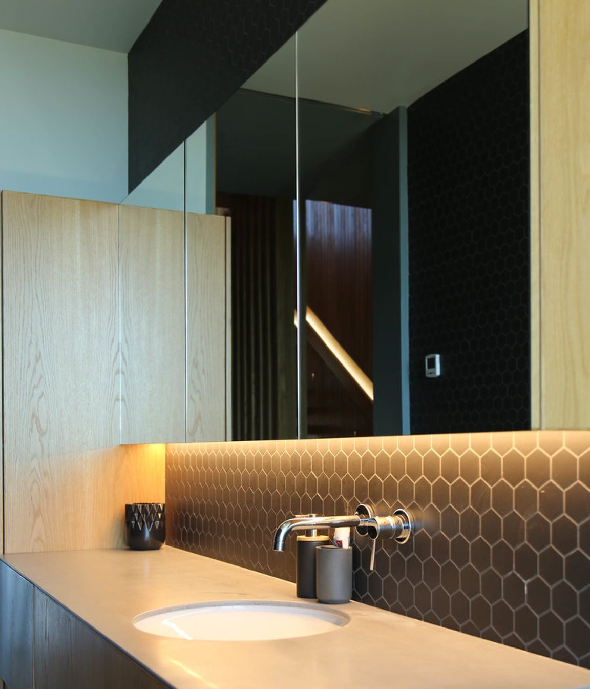 The bathroom continues a natural palette of materials theme.