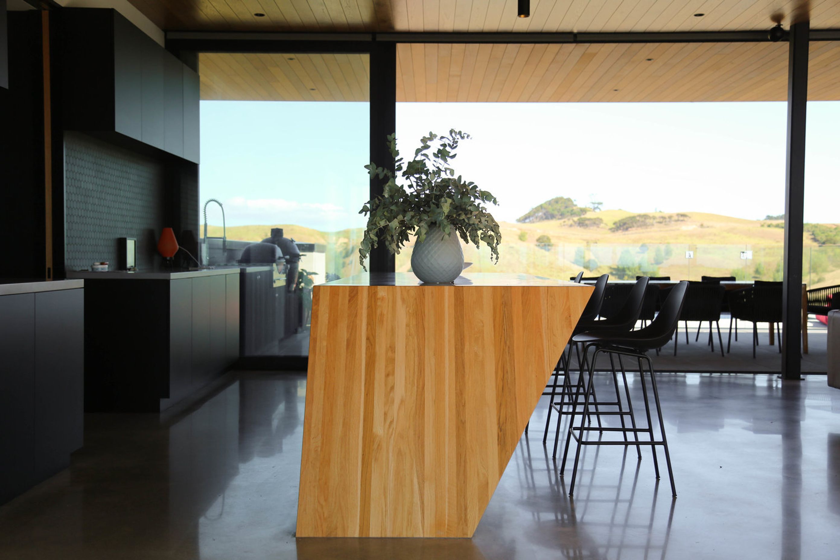 The slope of the bar can be seen more clearly from this view. The kitchen area opens up to the entertaining/pool area on one side (seen here) and the dining area on the other.