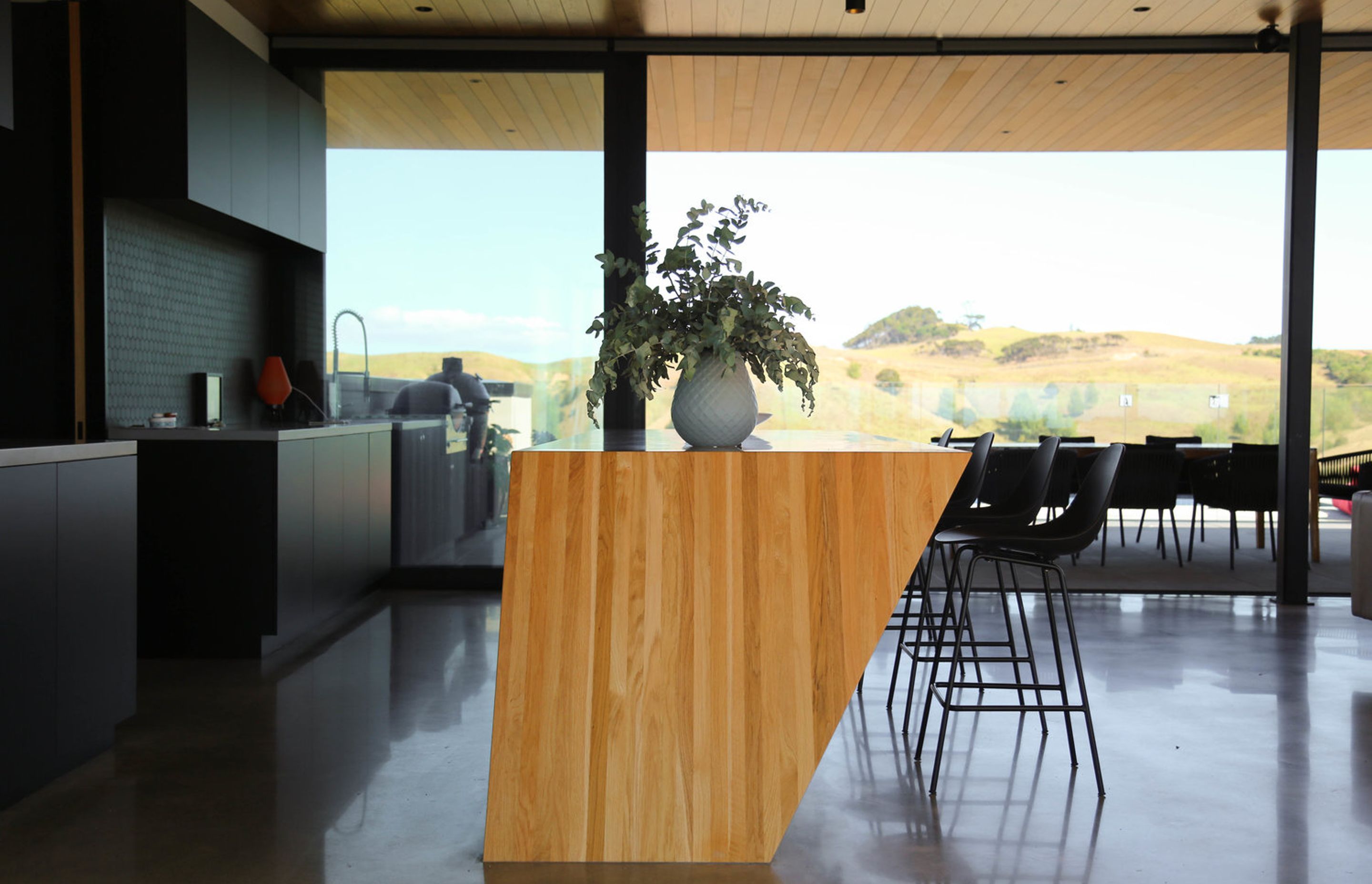 The slope of the bar can be seen more clearly from this view. The kitchen area opens up to the entertaining/pool area on one side (seen here) and the dining area on the other.