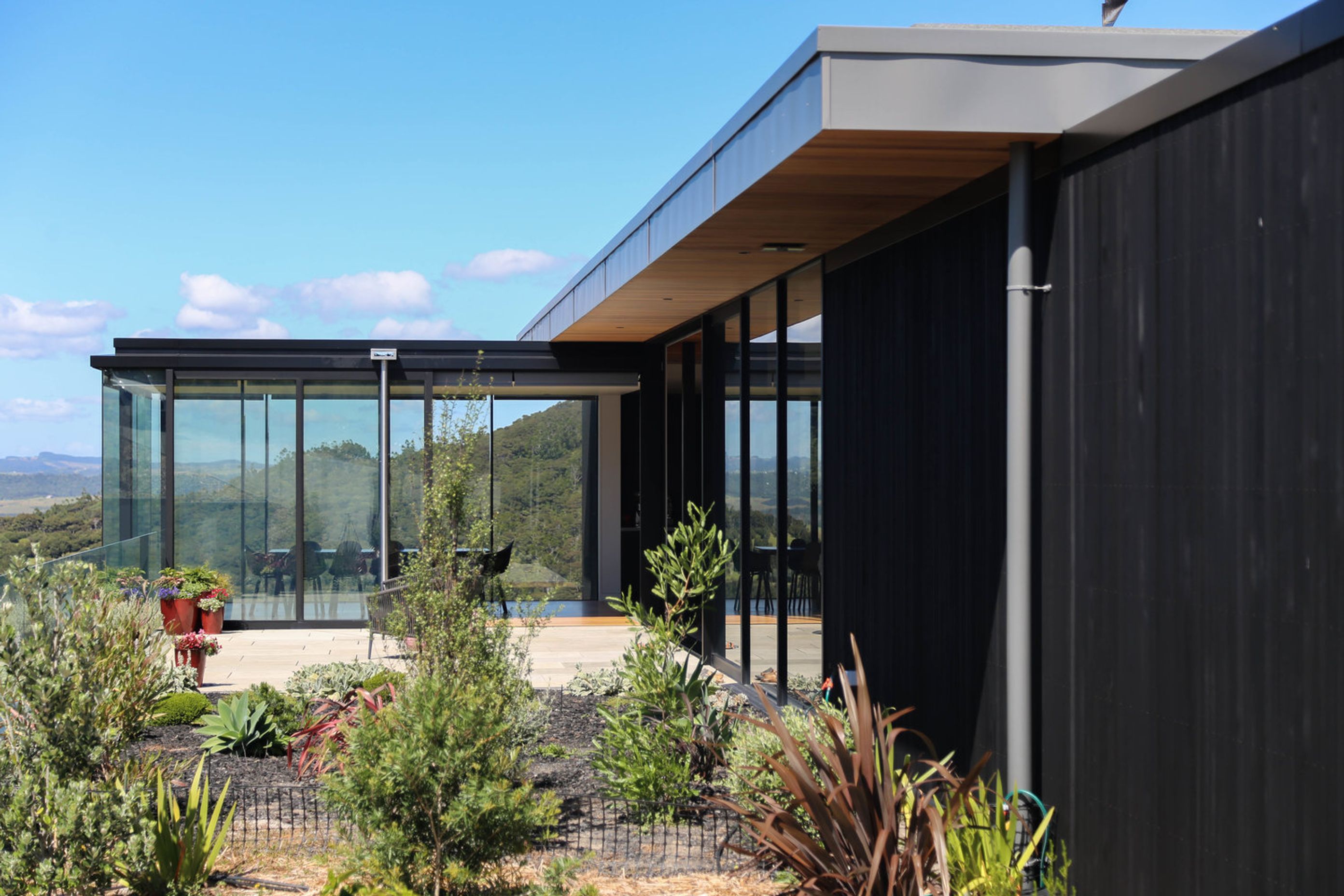 The glazed dining space seen through the newly landscaped garden and courtyard.