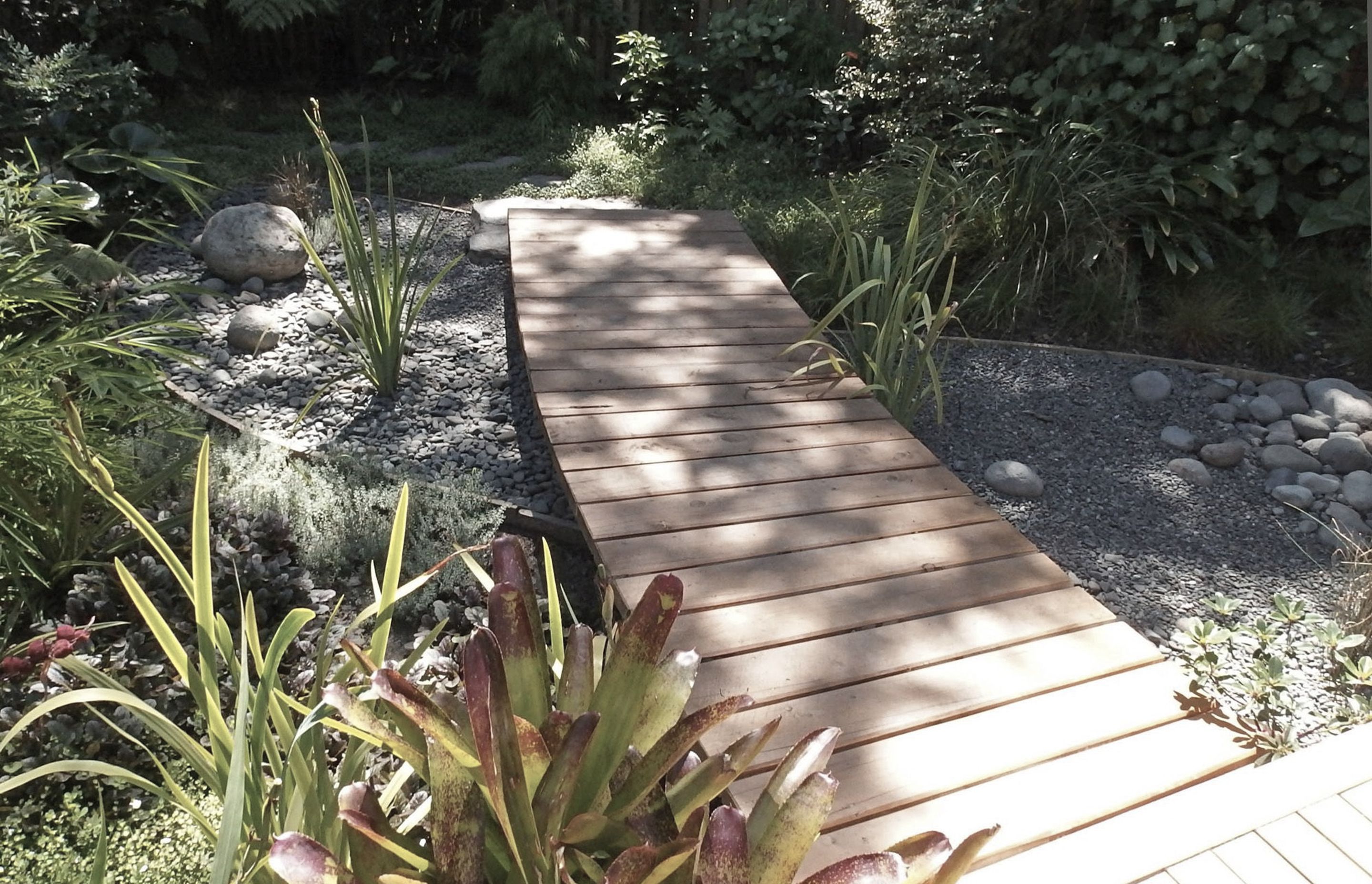 A boardwalk over the rain garden attended by lush planting