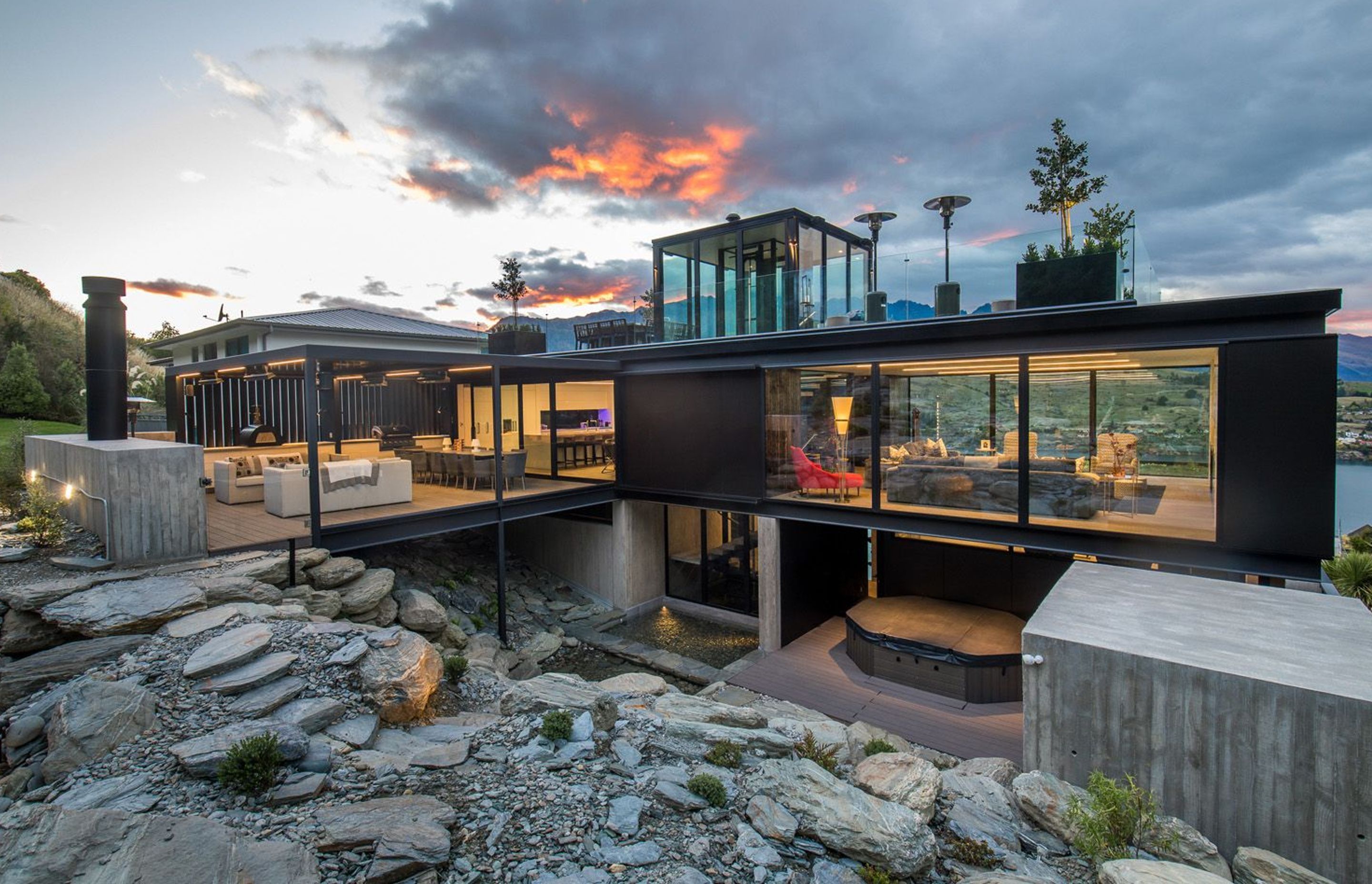 A rock garden at the rear has been excavated to create space for a spa and sauna area, and a reflection pool, which are overlooked by the outdoor room above.