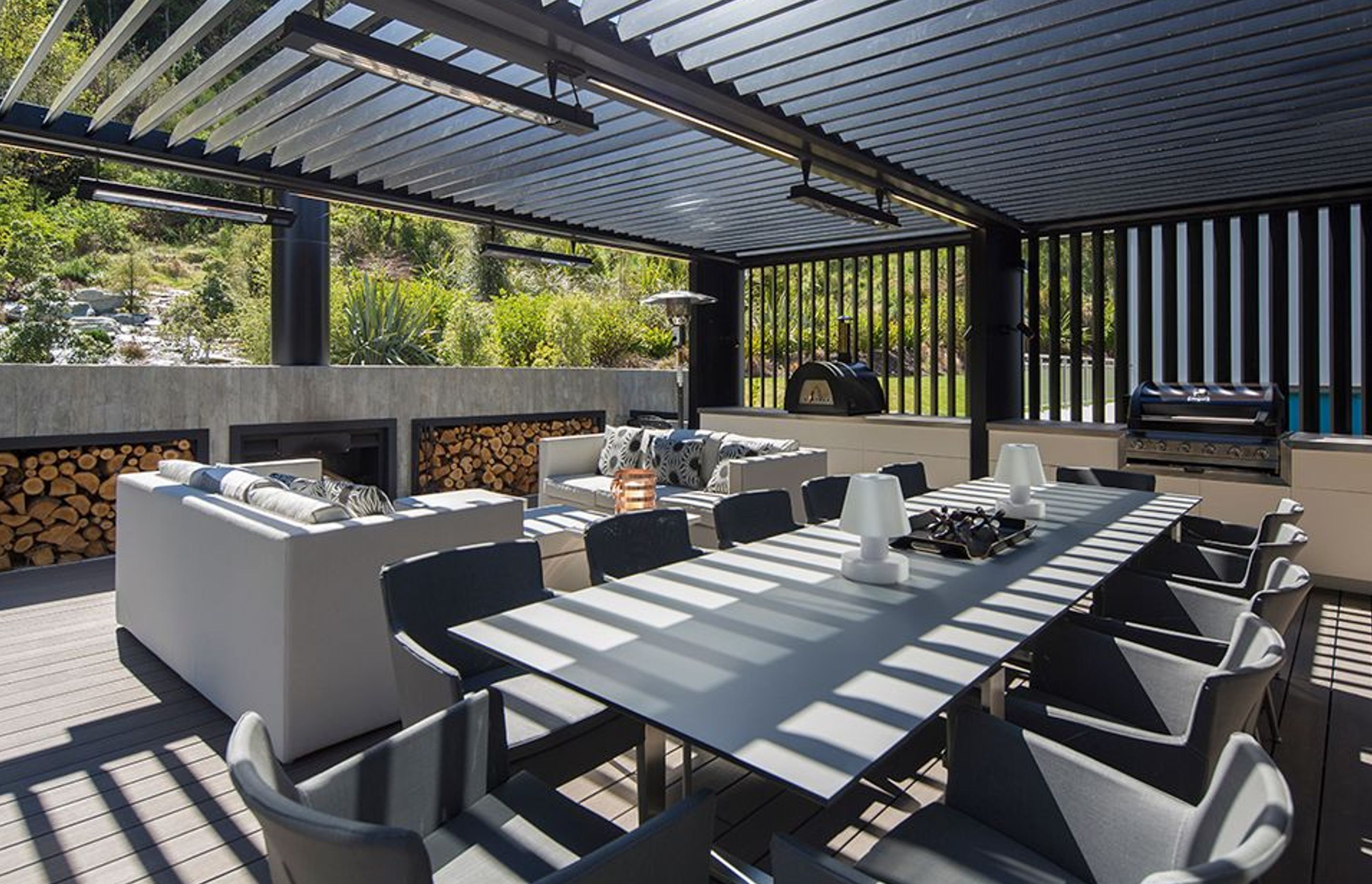 A built-in outdoor fireplace heats up the lounge area, while the pizza oven and barbecue provides the feast. The outdoor kitchen is an extension of the indoor kitchen to the right.