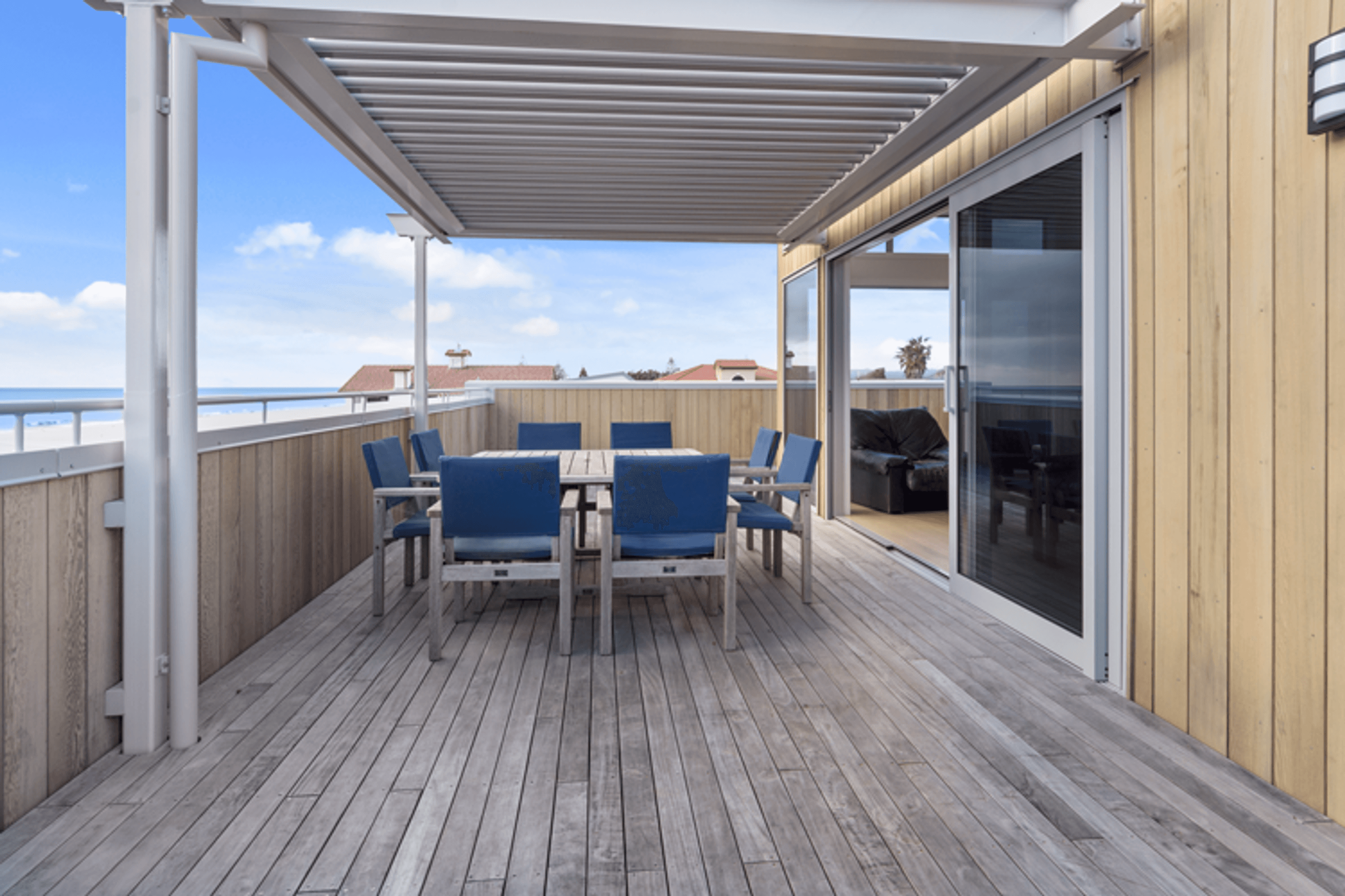 The Glass sliders connecting the living space to the outdoor decking welcome in the sea air and open onto the alfresco dining space which is under the Louvretec roof.