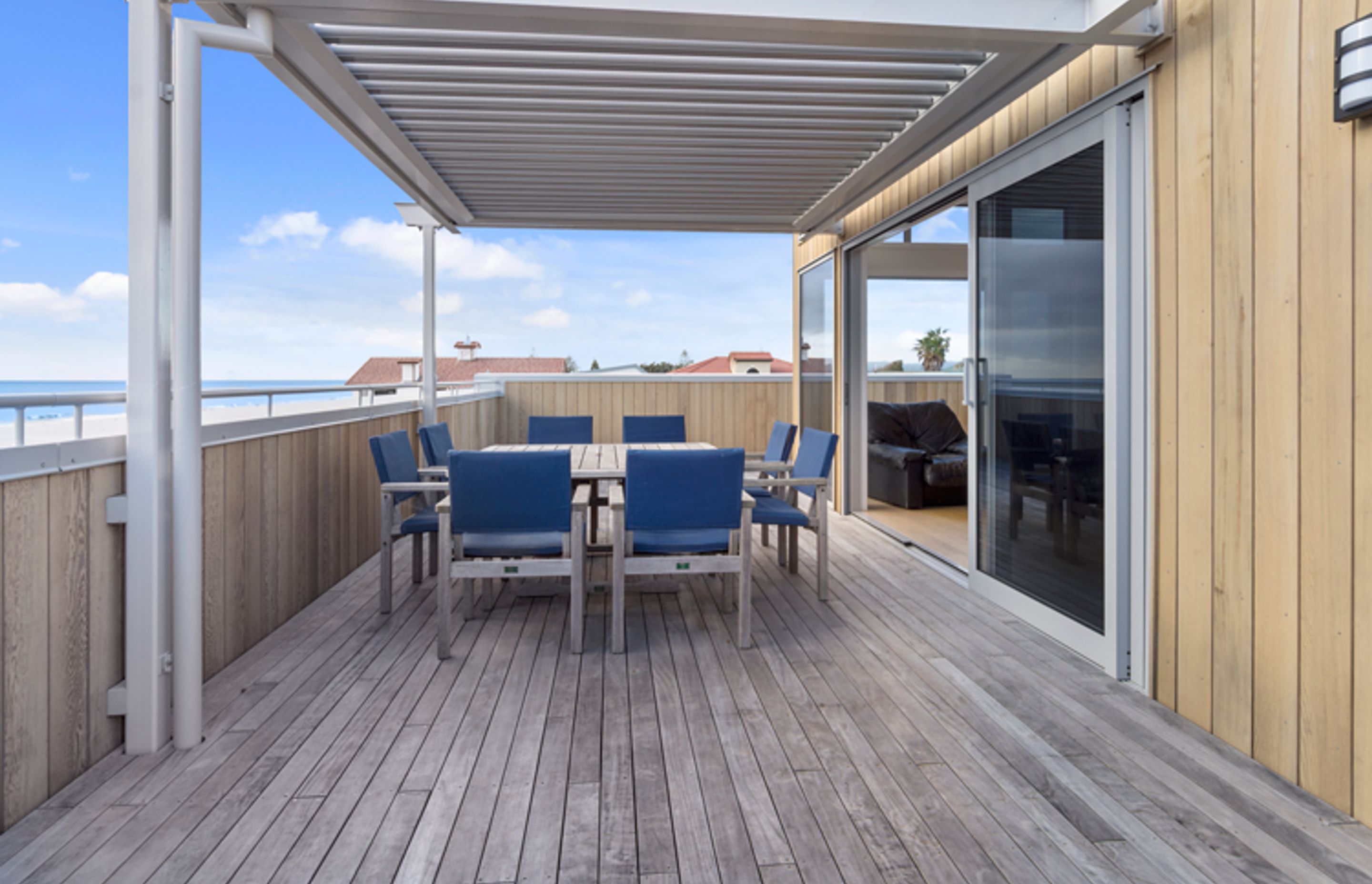 The Glass sliders connecting the living space to the outdoor decking welcome in the sea air and open onto the alfresco dining space which is under the Louvretec roof. 