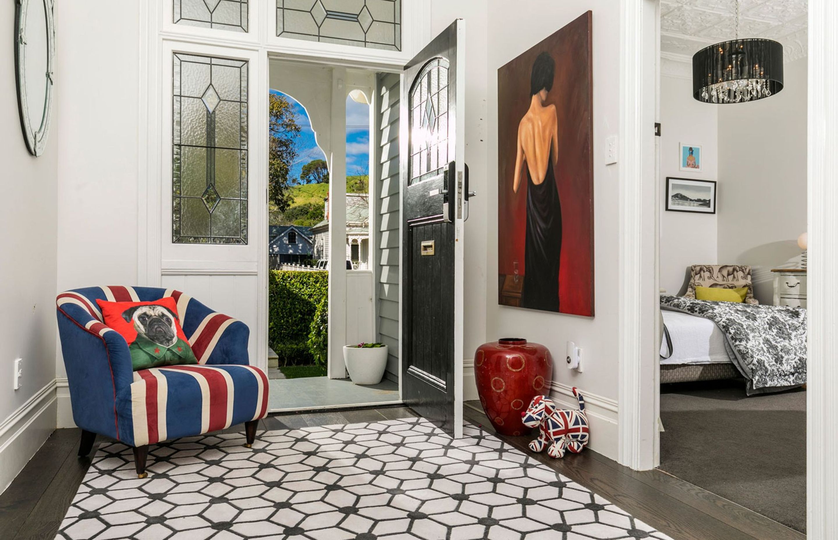 The eclectic entrance held a nod to the clients english heritage, and the custom designed rug echoed the pattern in the stained glass with it's diamond shapes.
