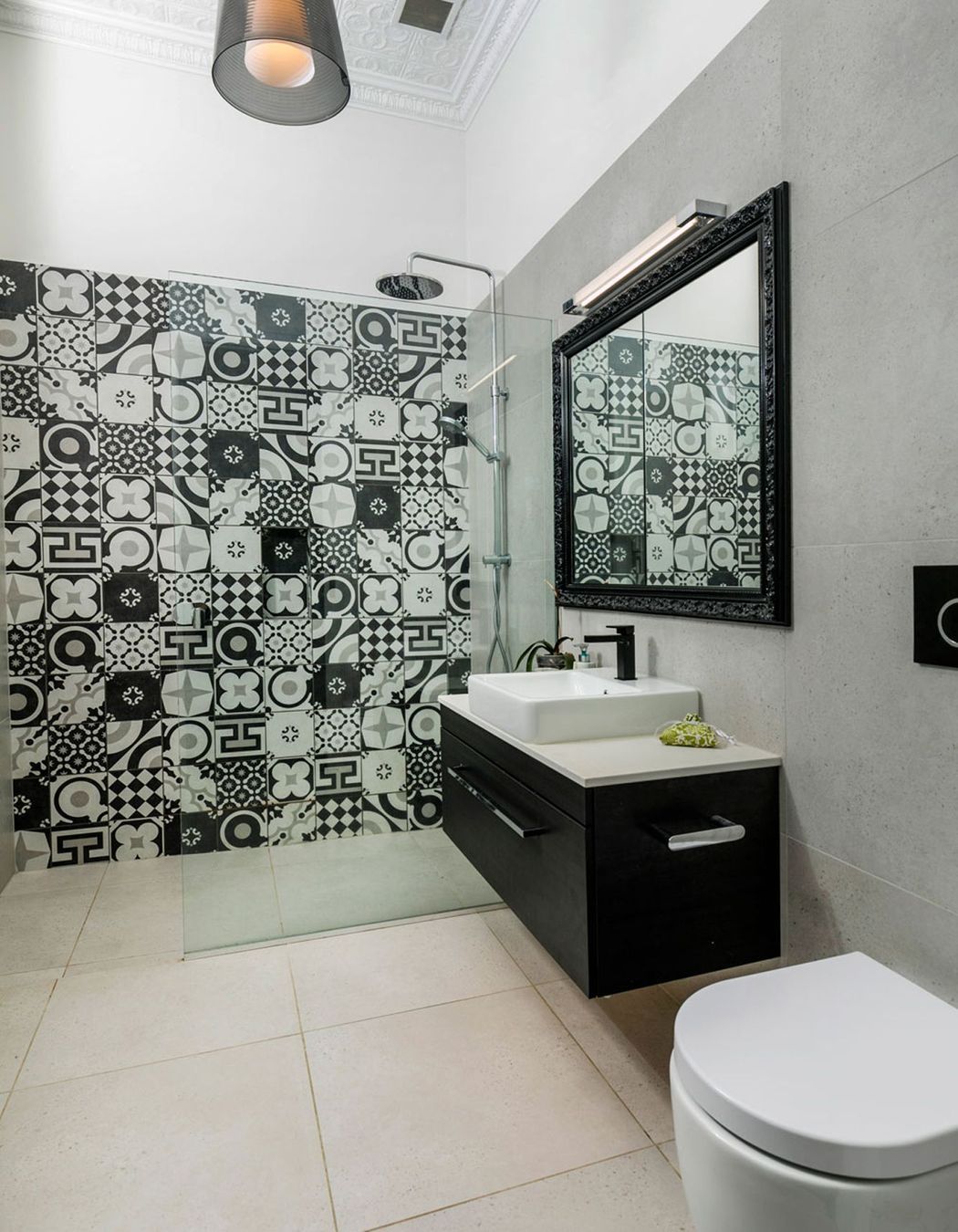 Bold patterns tiles created a feature in the bathrooms, and the mirror was designed with a picture frame around it to create a difference to the ordinary recessed mirror cabinet.