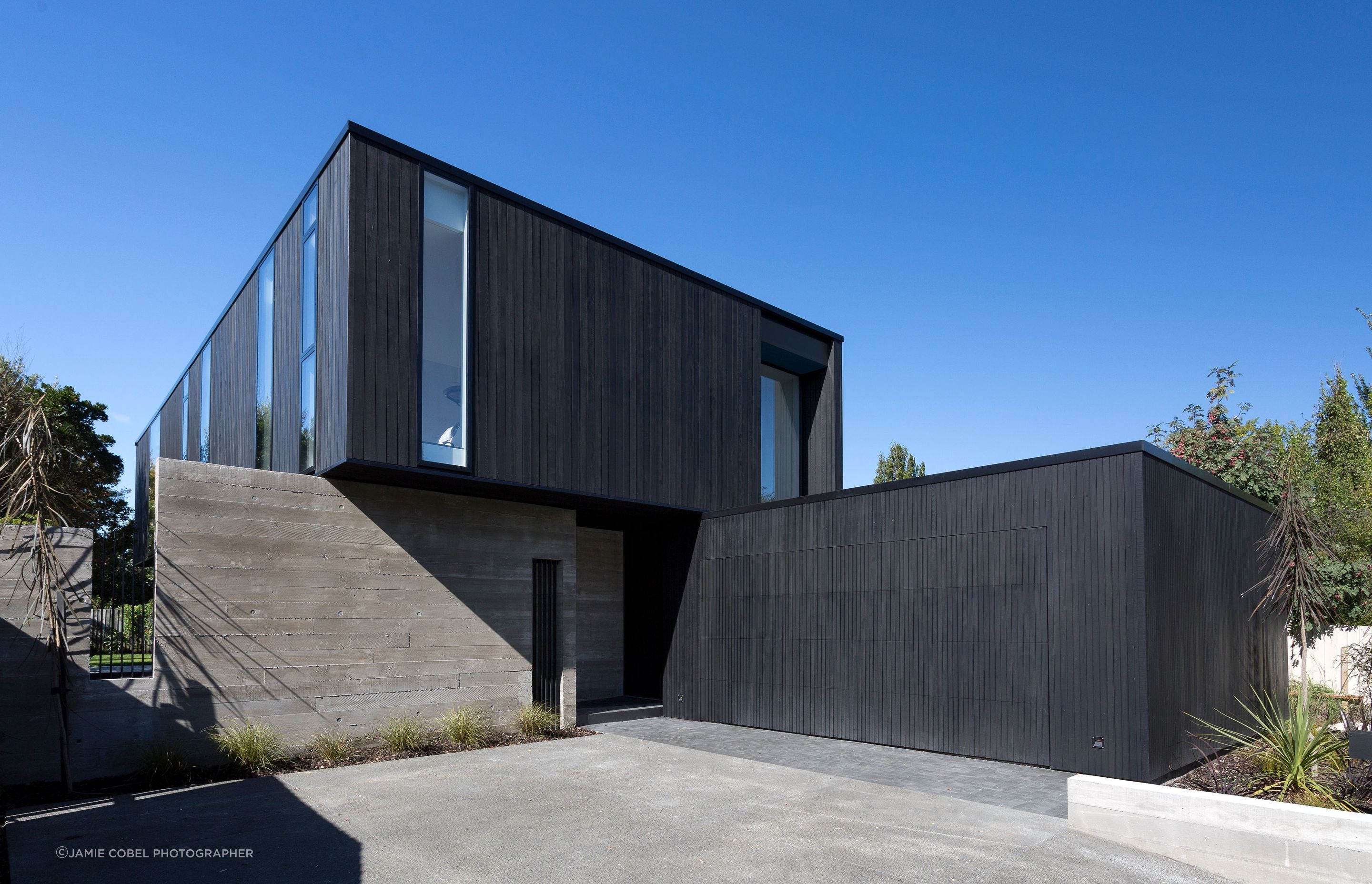 The verticality of the cedar and glass is contrasted by the horizontality of the concrete walls. A discreet garage door becomes a flat black cedar wall when closed.