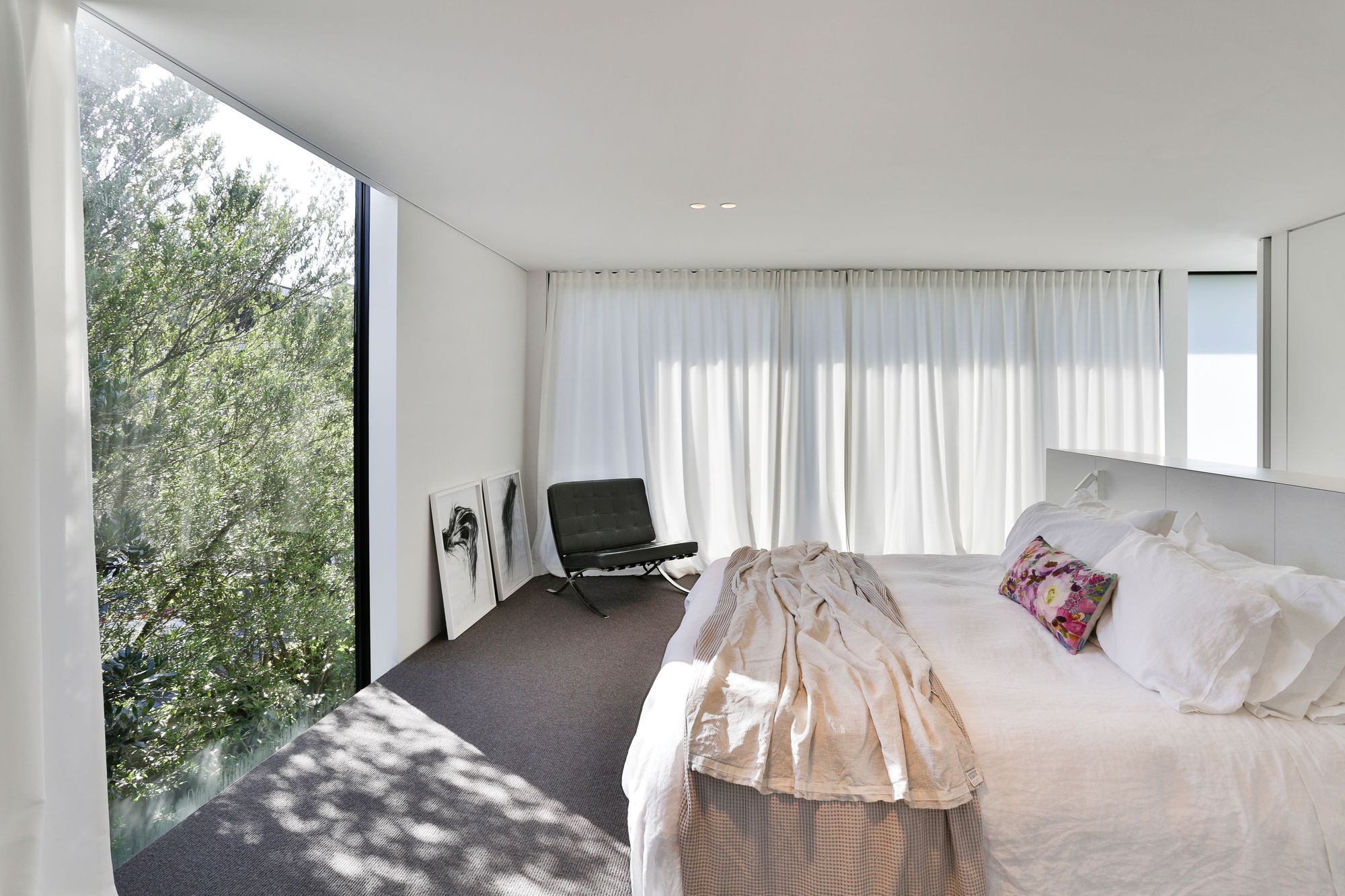 The master suite is a sanctuary for the client and when they lay in bed, they look directly out over the tree tops through glazing that extends beyond the flooring and the ceiling edges.