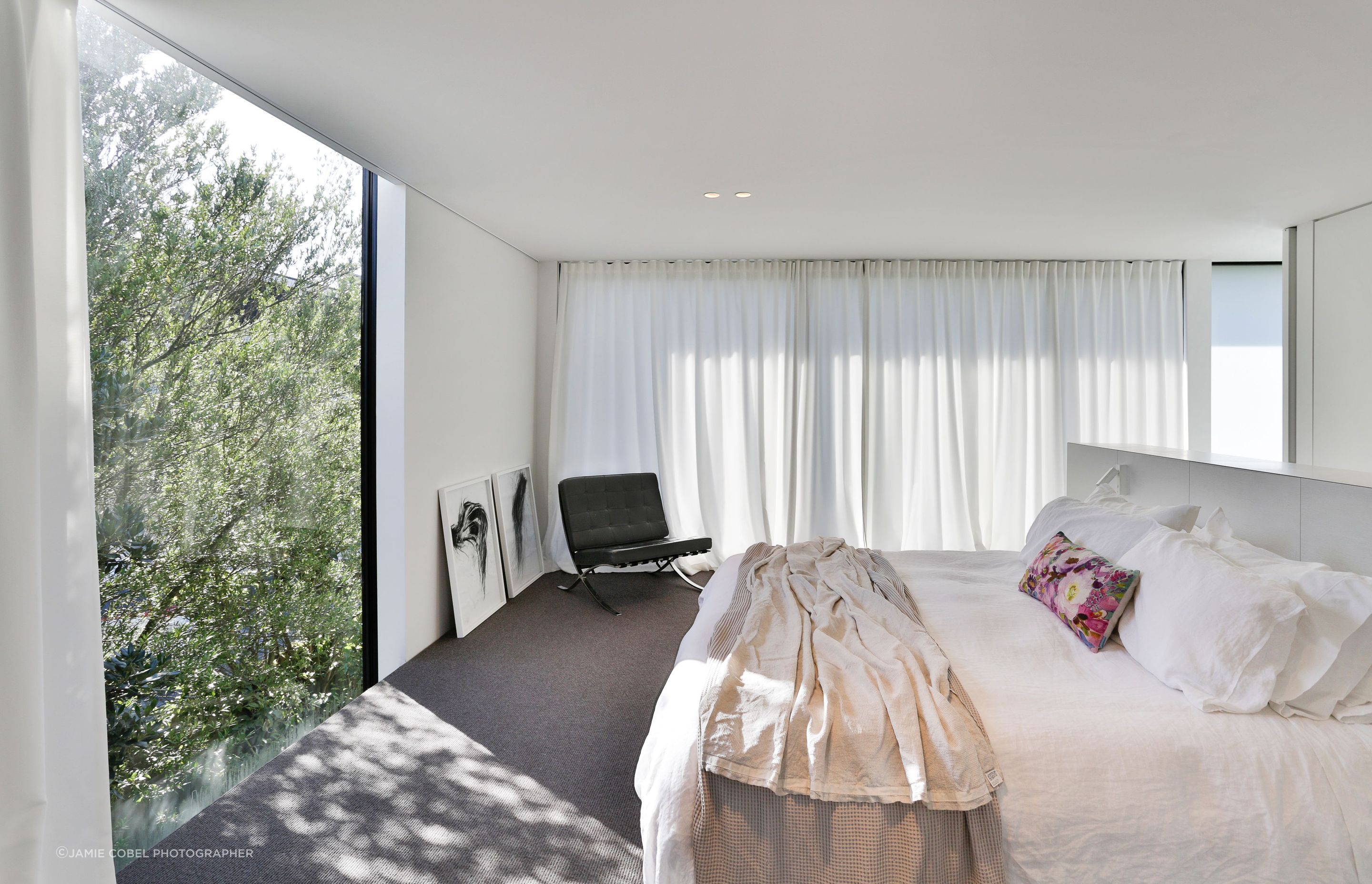 The master suite is a sanctuary for the client and when they lay in bed, they look directly out over the tree tops through glazing that extends beyond the flooring and the ceiling edges.
