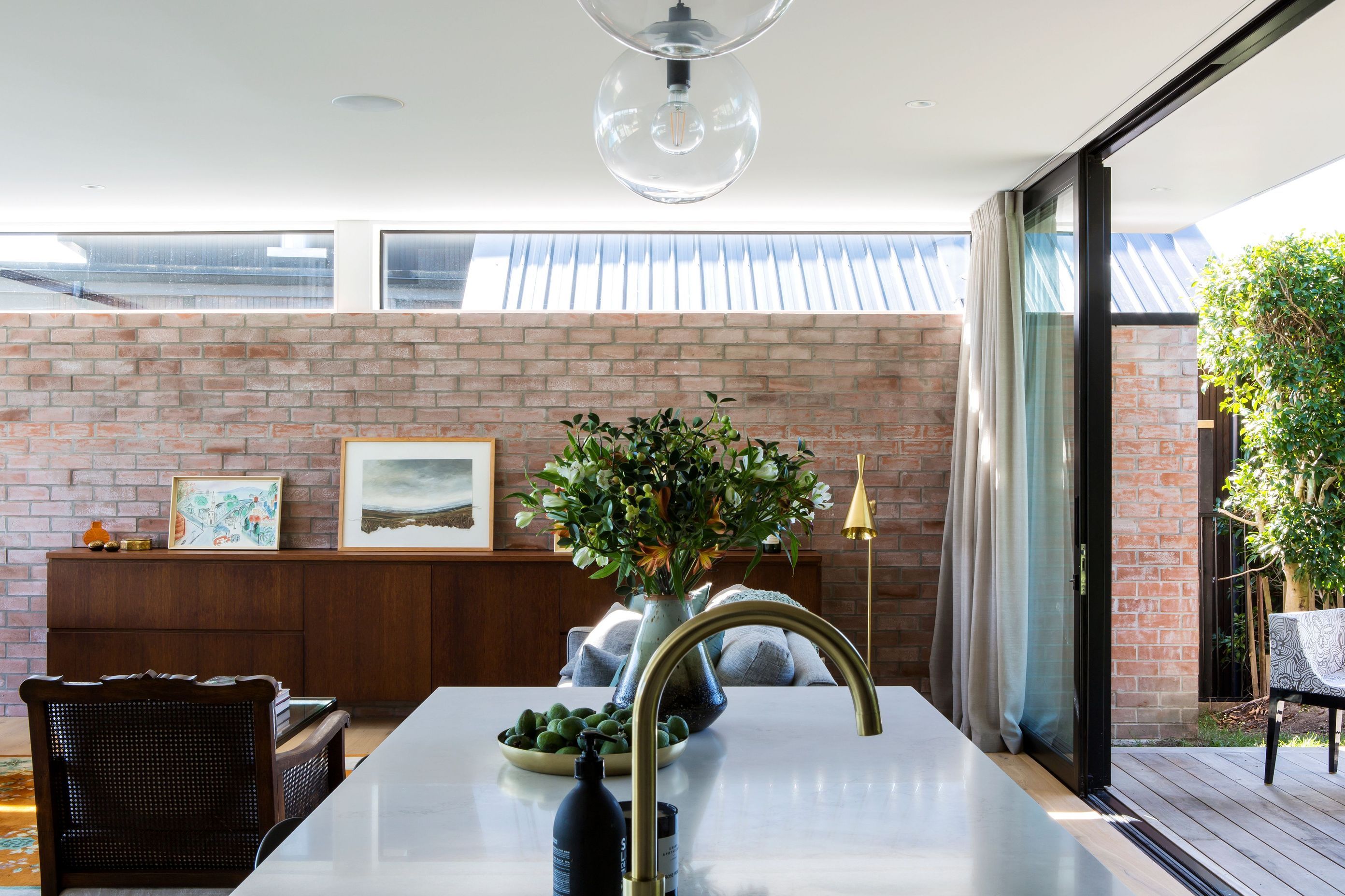 A feature wall in the lounge showcases recycled bricks from the previous brick-and-tile house on the site that was demolished to make room for this home.