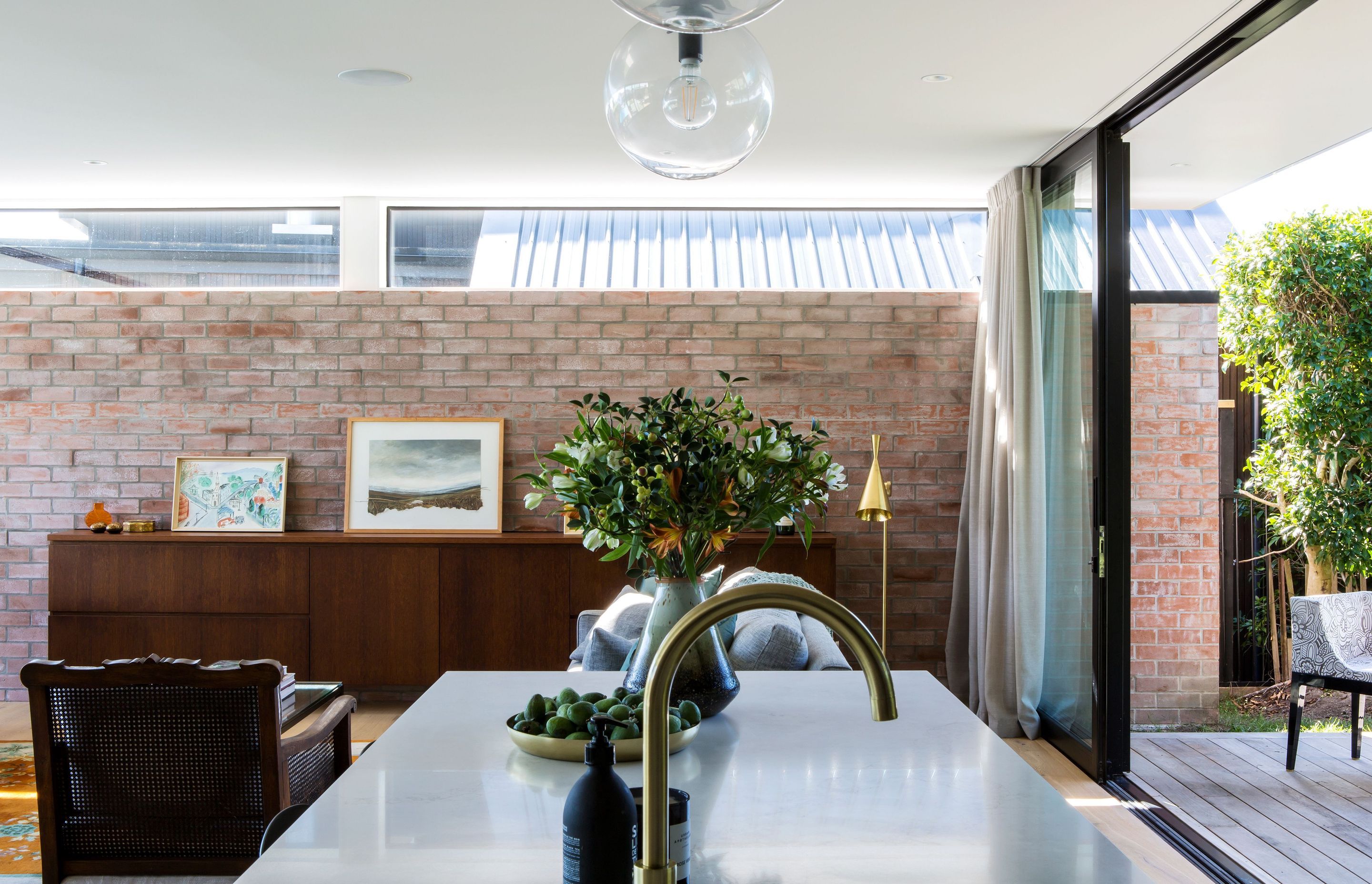 A feature wall in the lounge showcases recycled bricks from the previous brick-and-tile house on the site that was demolished to make room for this home.
