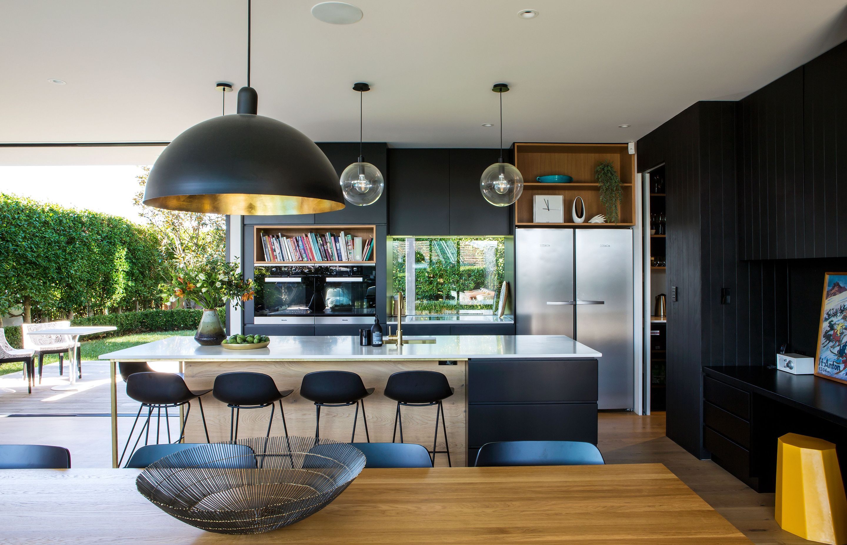 Unusually, a window has been placed behind the cooktop, replacing the kitchen splashback with an animated framed view of the garden.