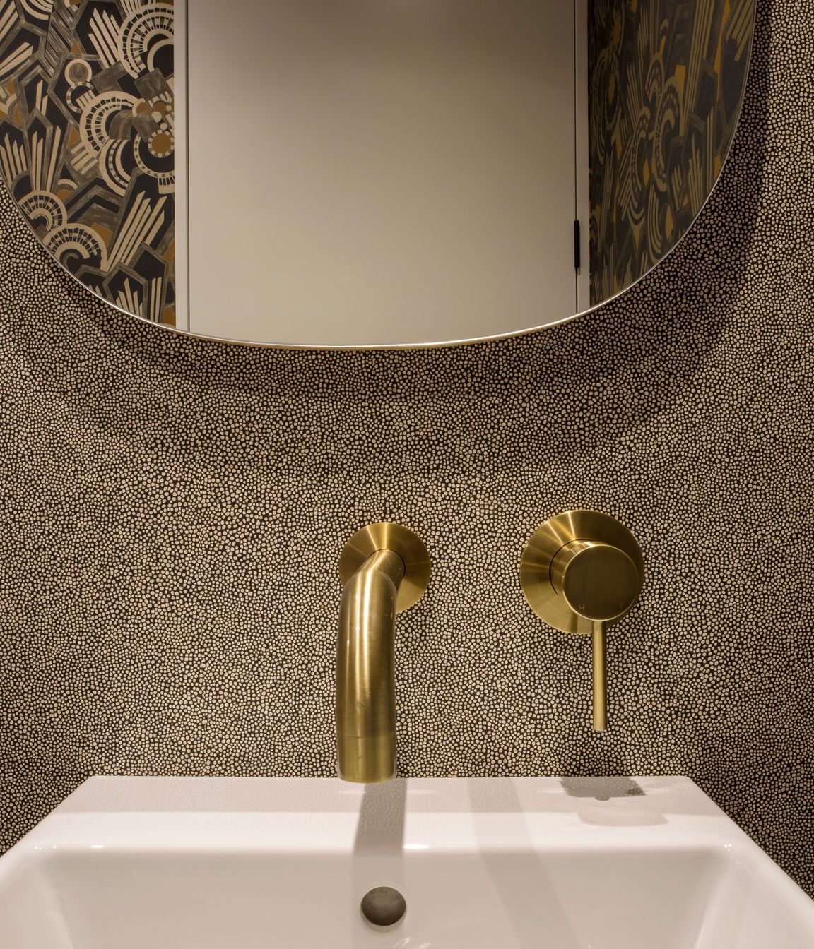 Brass tapware and retro wall coverings add personality to the powder room.