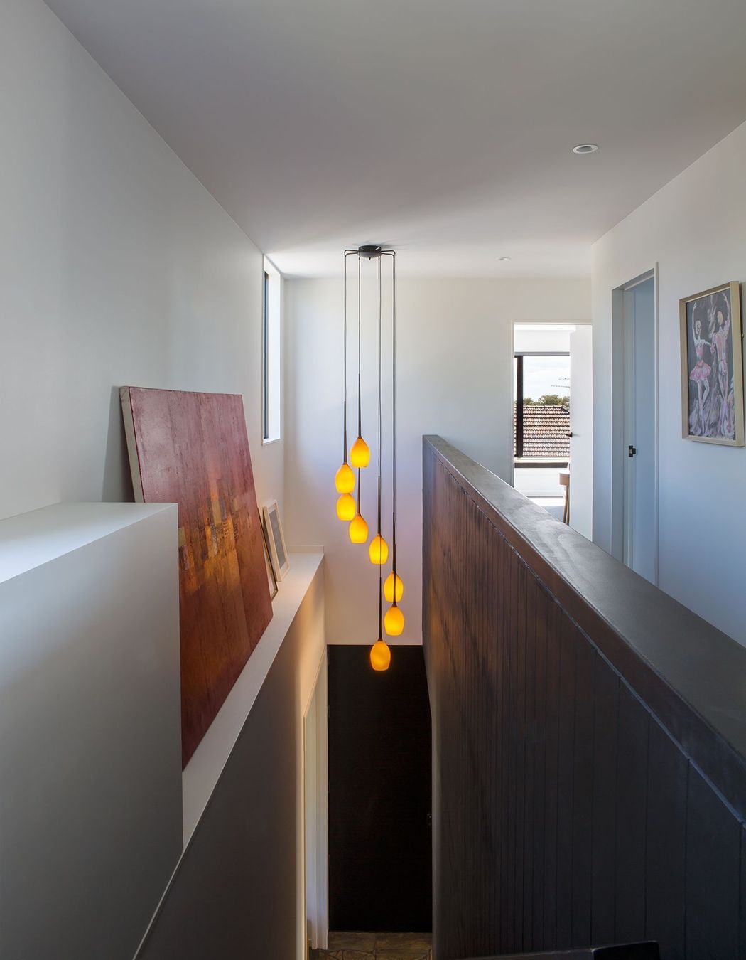 Artworks and a feature light take centre stage in the double-height staircase.
