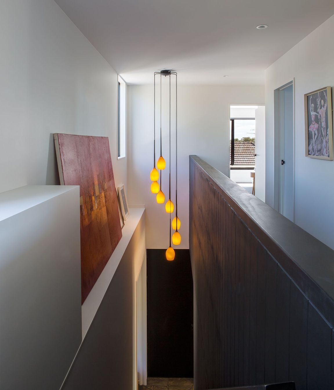 Artworks and a feature light take centre stage in the double-height staircase.