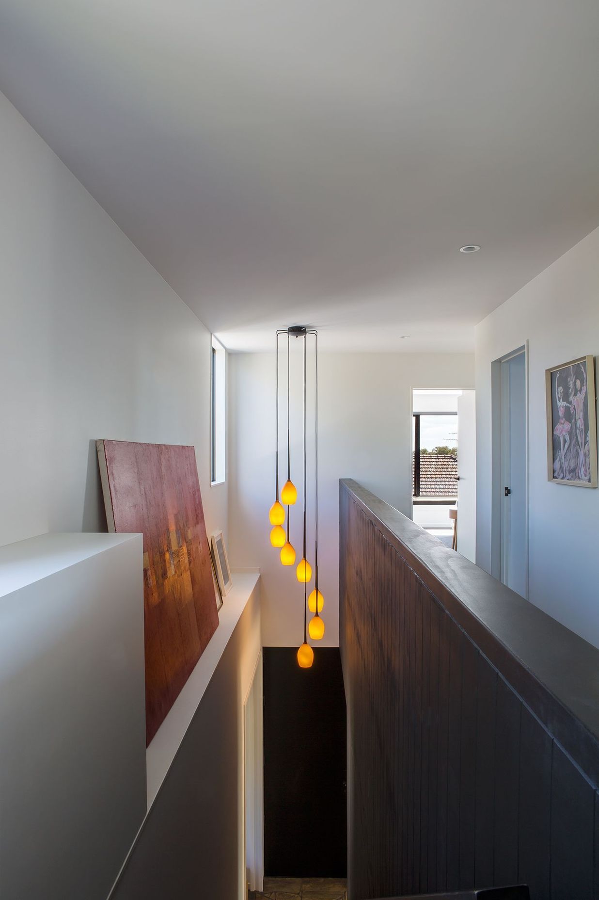Artworks and a feature light take centre stage in the double-height staircase.