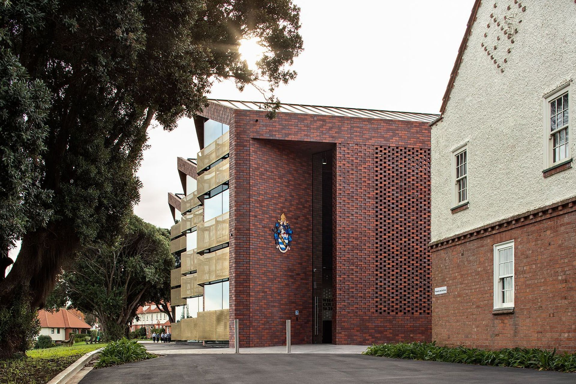 The double-height angled entry into the new administration/arrivals building utilises brick as a material reference to the old school.
