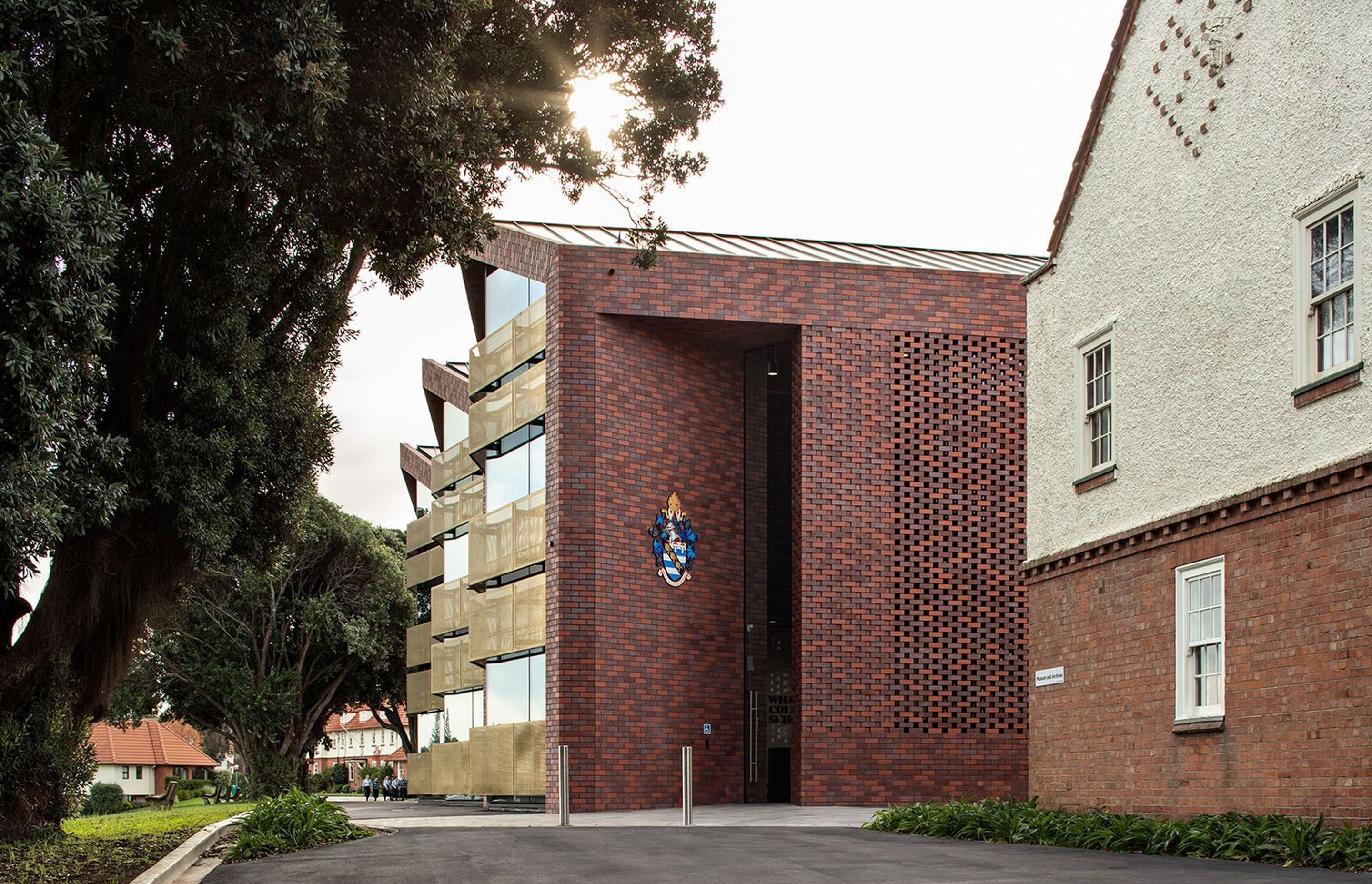 The double-height angled entry into the new administration/arrivals building utilises brick as a material reference to the old school.