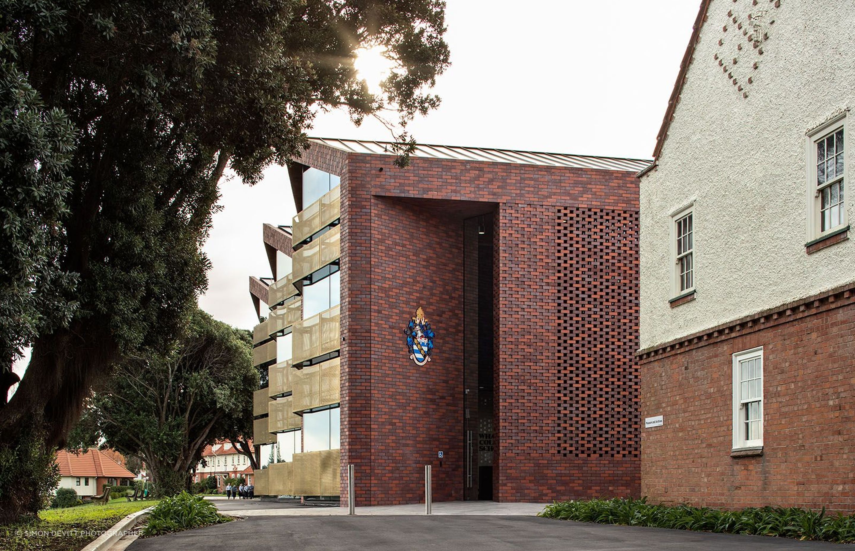 The double-height angled entry into the new administration/arrivals building utilises brick as a material reference to the old school.