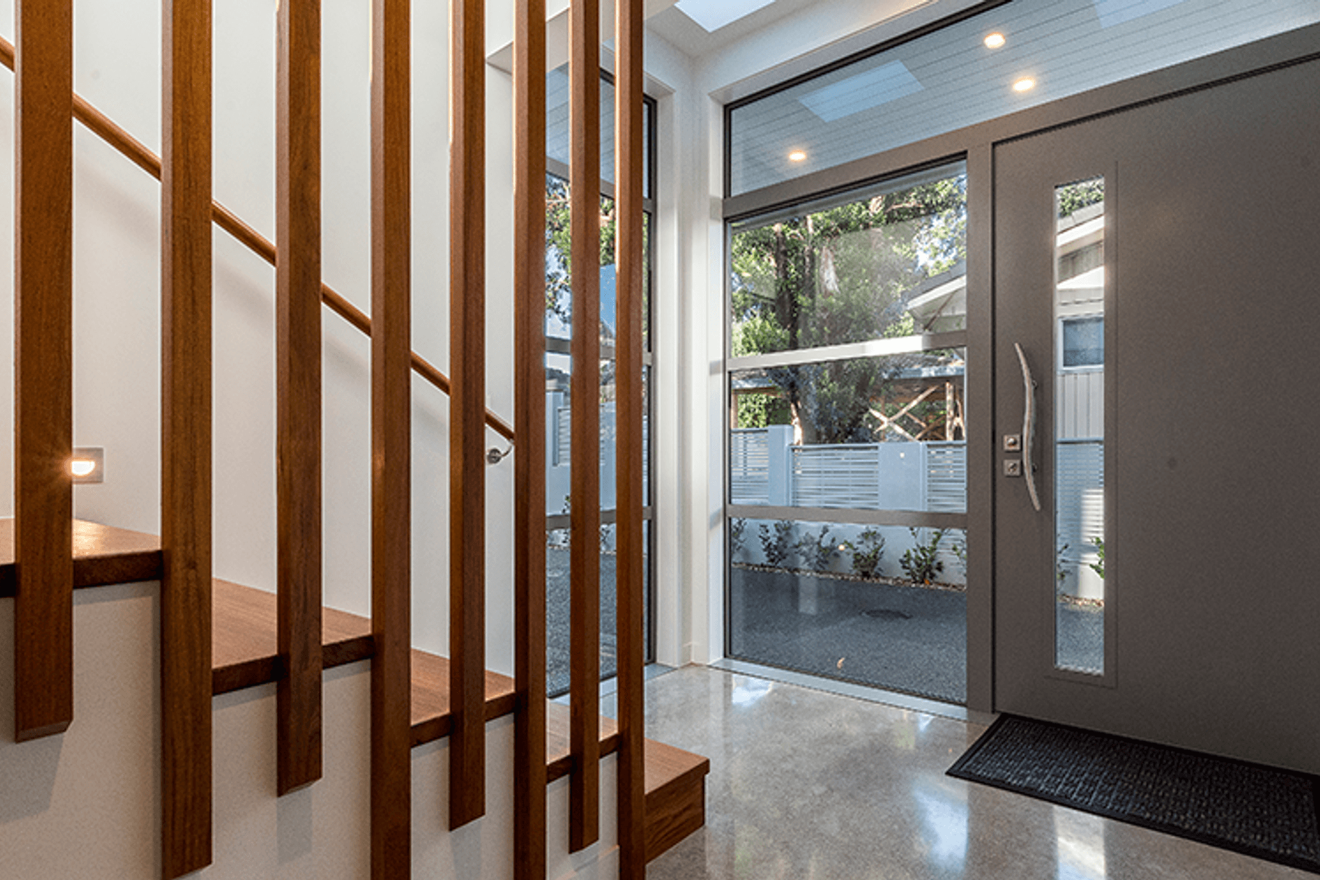 The entry features a hardwood staircase and cloakroom and polished concrete floors throughout.