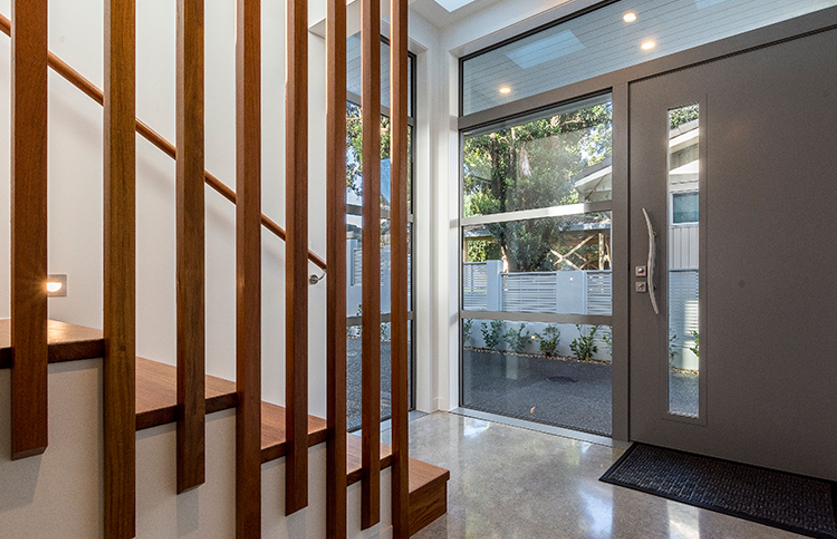 The entry features a hardwood staircase and cloakroom and polished concrete floors throughout.