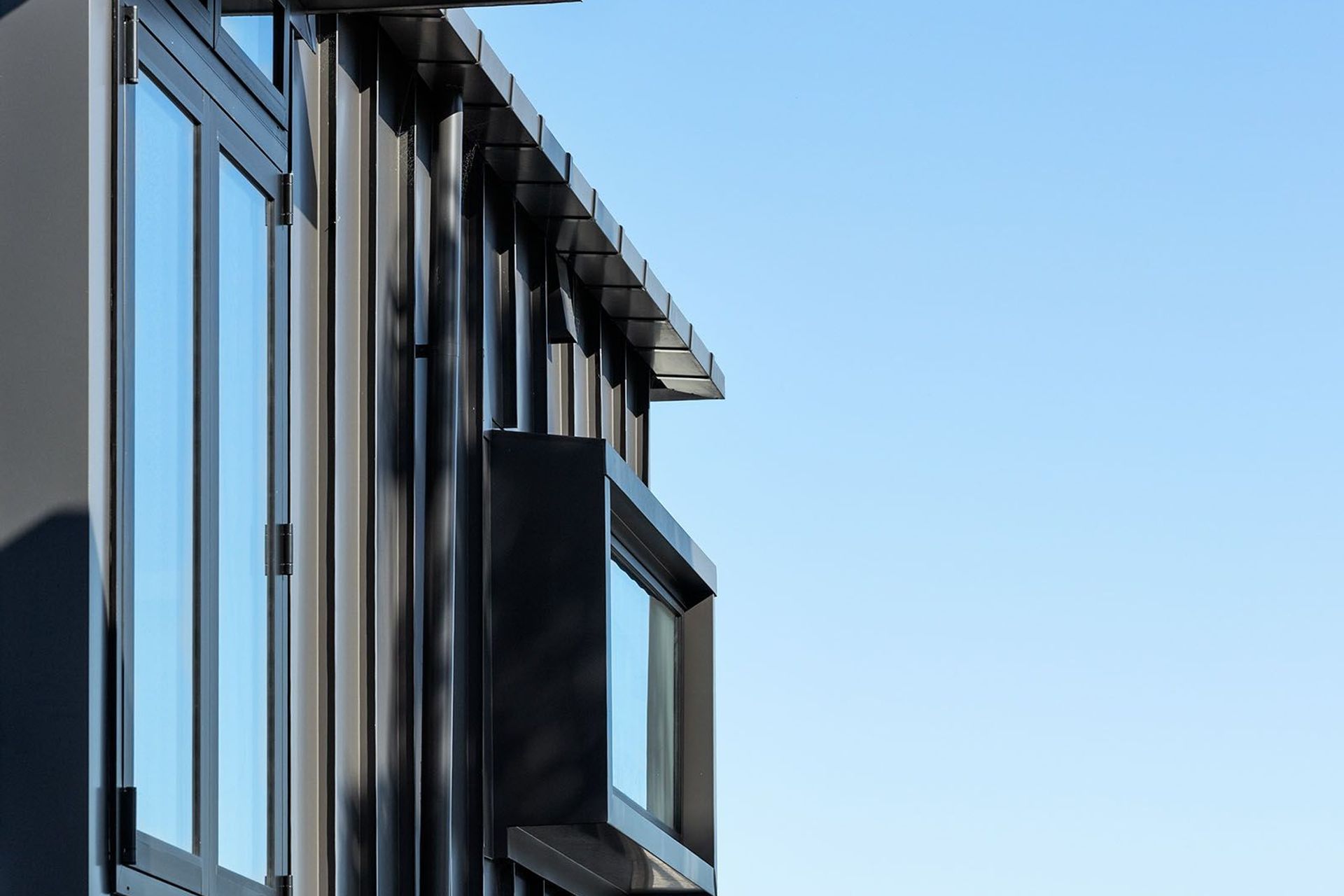 Standing seam aluminium cladding is used on the exterior of the third storey.