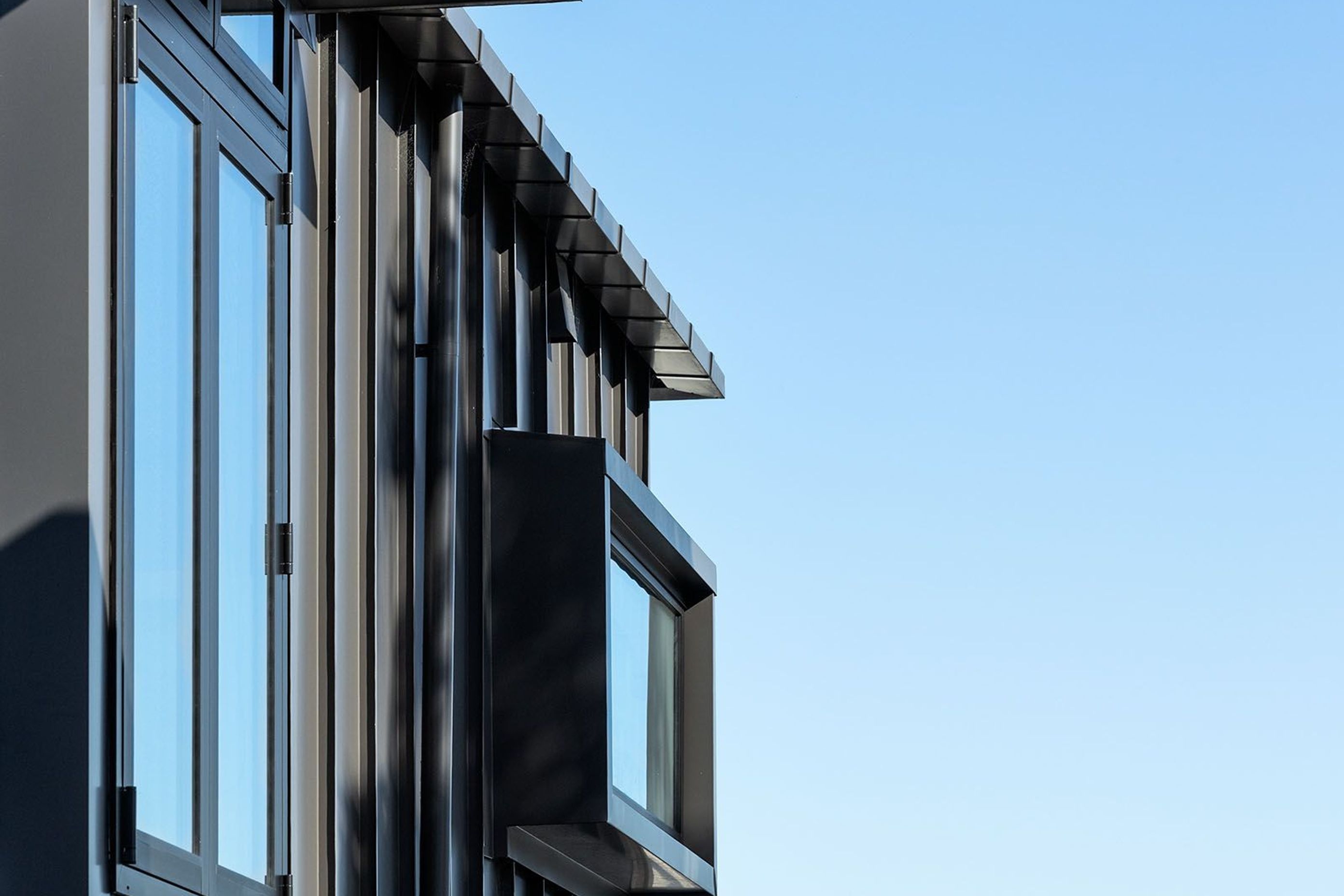 Standing seam aluminium cladding is used on the exterior of the third storey.